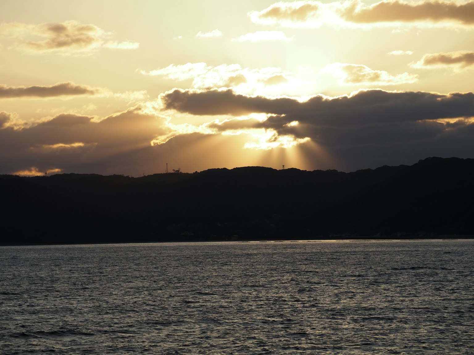 Bellissimo paesaggio marino con raggi di sole al tramonto che attraversano le nuvole