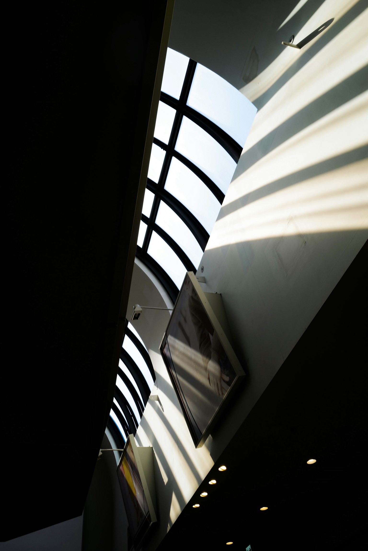 Intérieur d'un bâtiment moderne avec un plafond incliné et des reflets lumineux saisissants