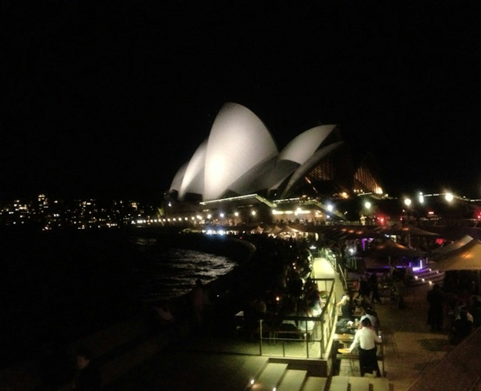 Vue nocturne de l'Opéra de Sydney avec des lumières environnantes