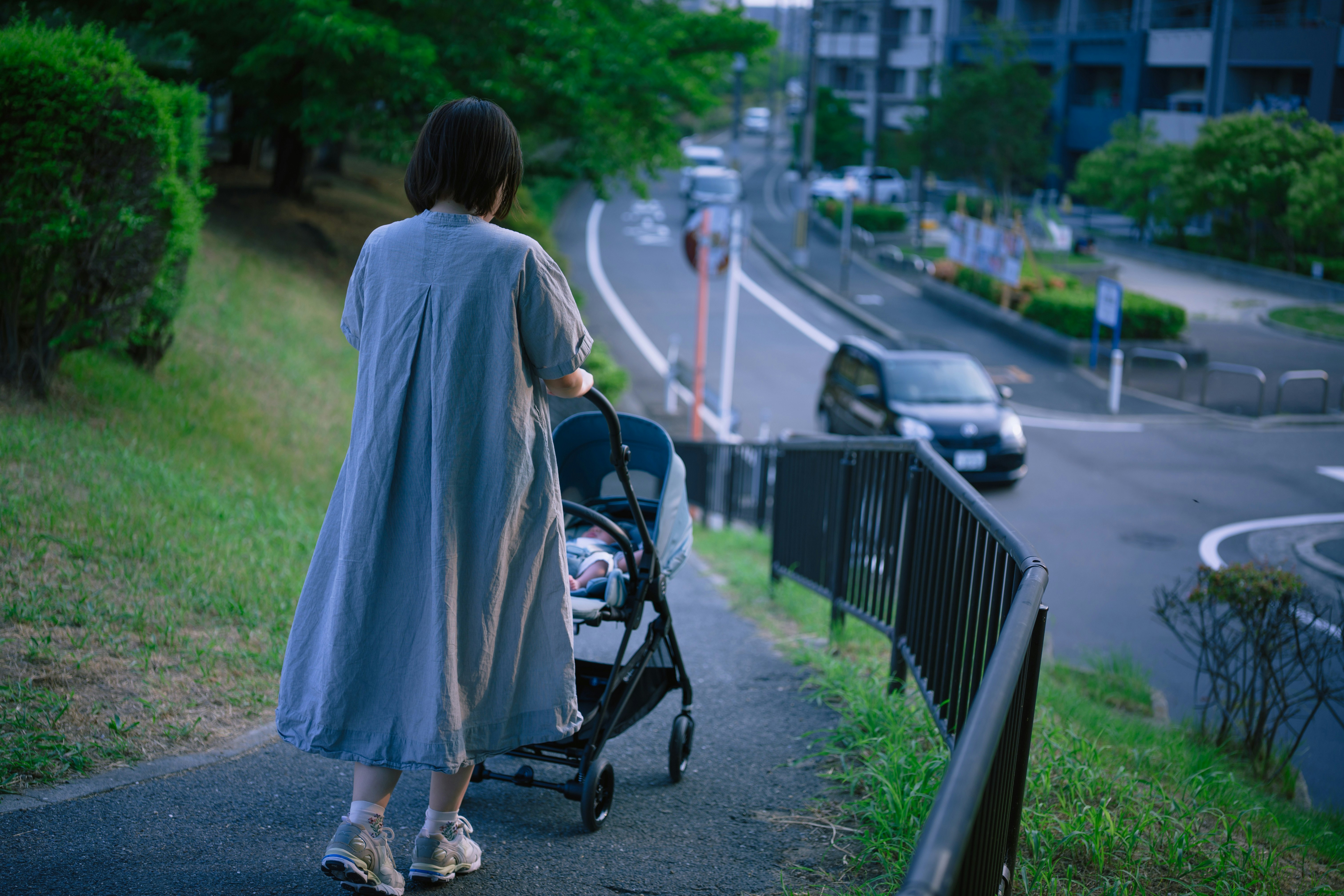 rear view of a person pushing a stroller on a residential street