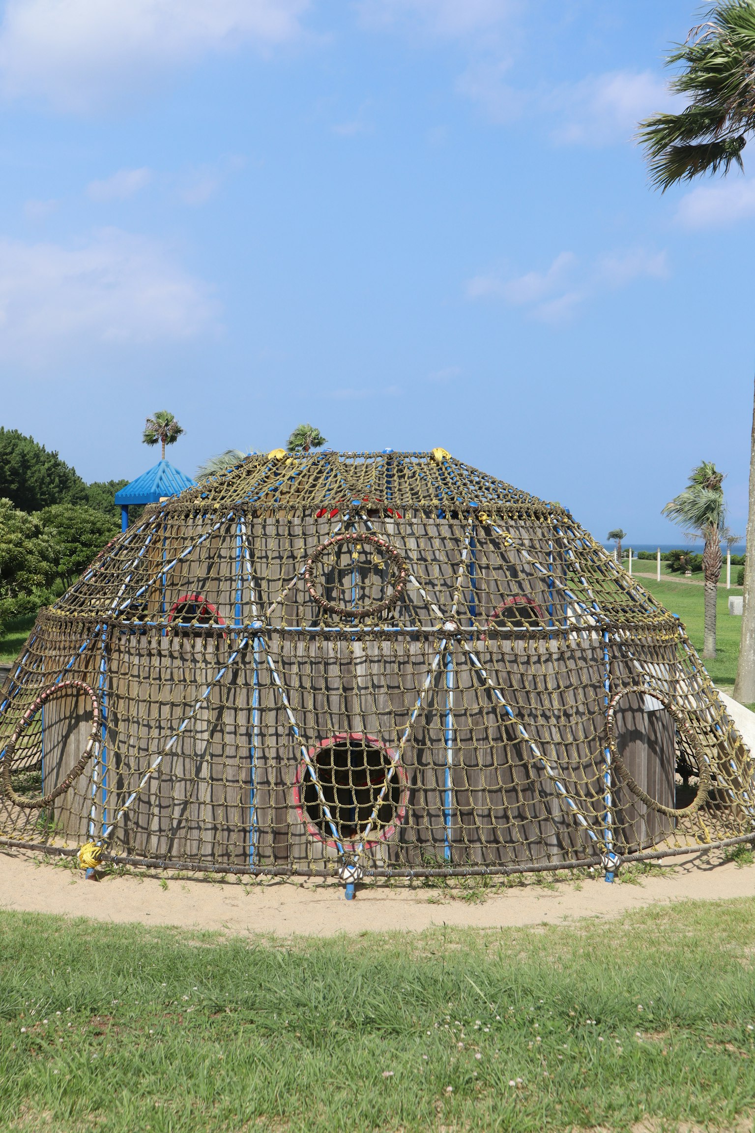 Structure ronde en paille sous un ciel bleu avec de l'herbe verte autour