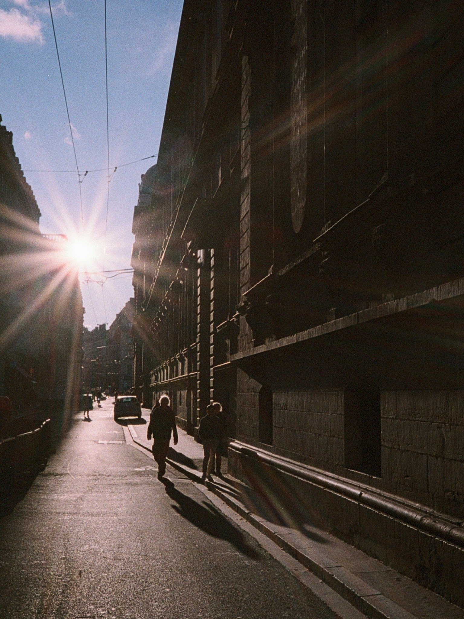 夕日が差し込む街路を歩く人々のシルエット