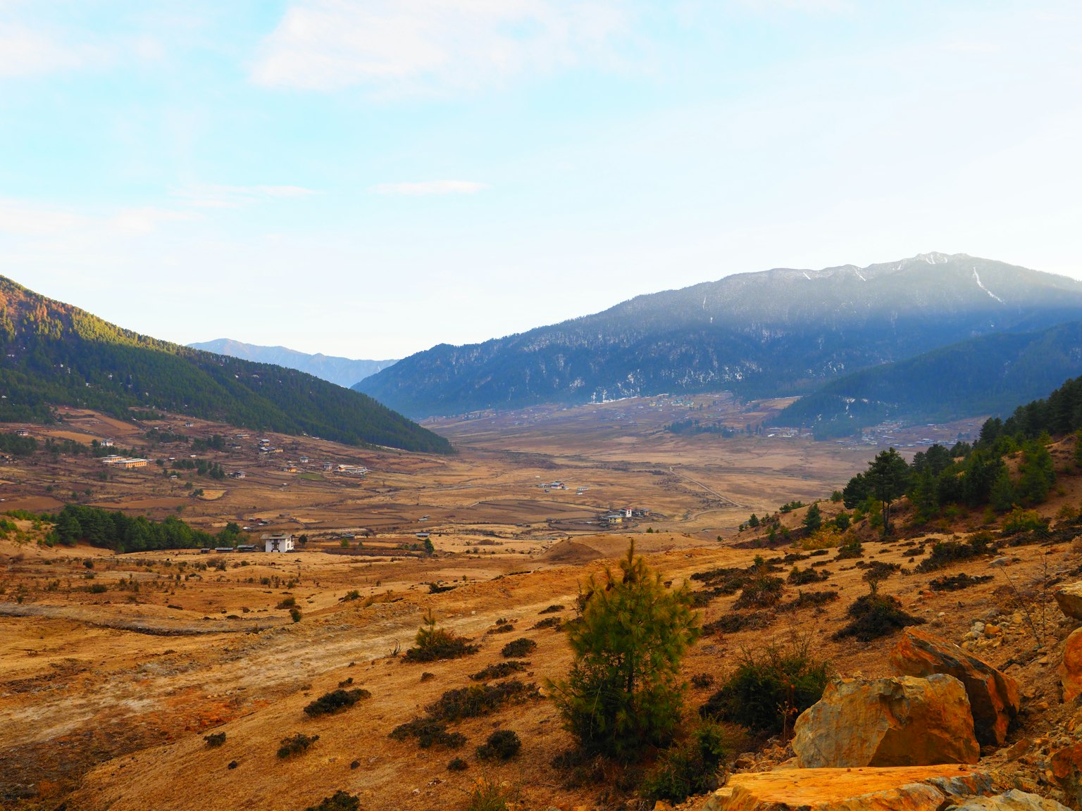 Vast dry valley landscape with mountains in the background