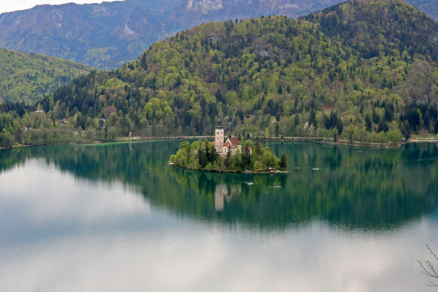 Eine mittelalterliche Burg auf einer Insel in einem ruhigen See, umgeben von üppigen Bergen