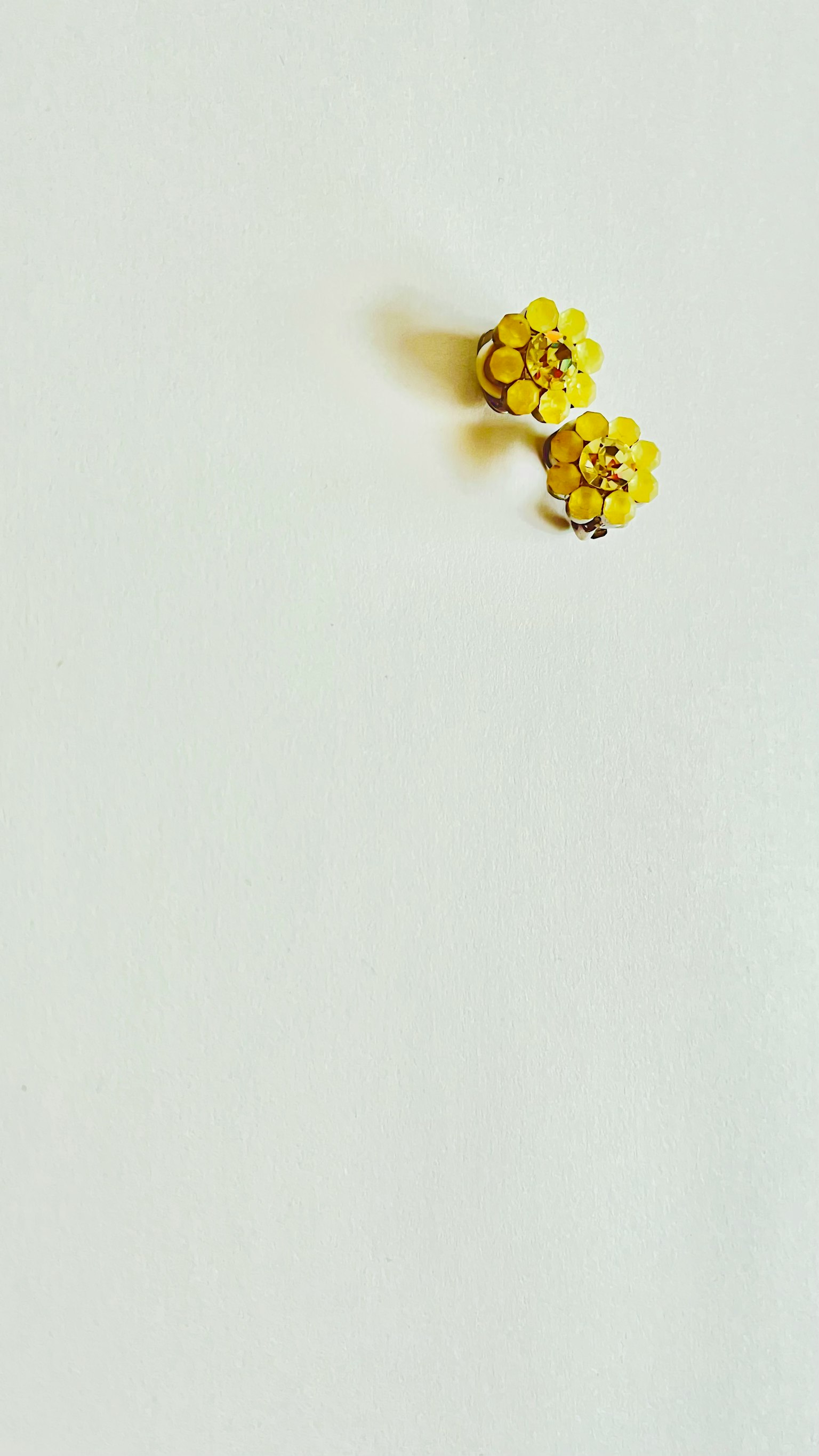 Spilla a forma di fiore giallo su sfondo bianco