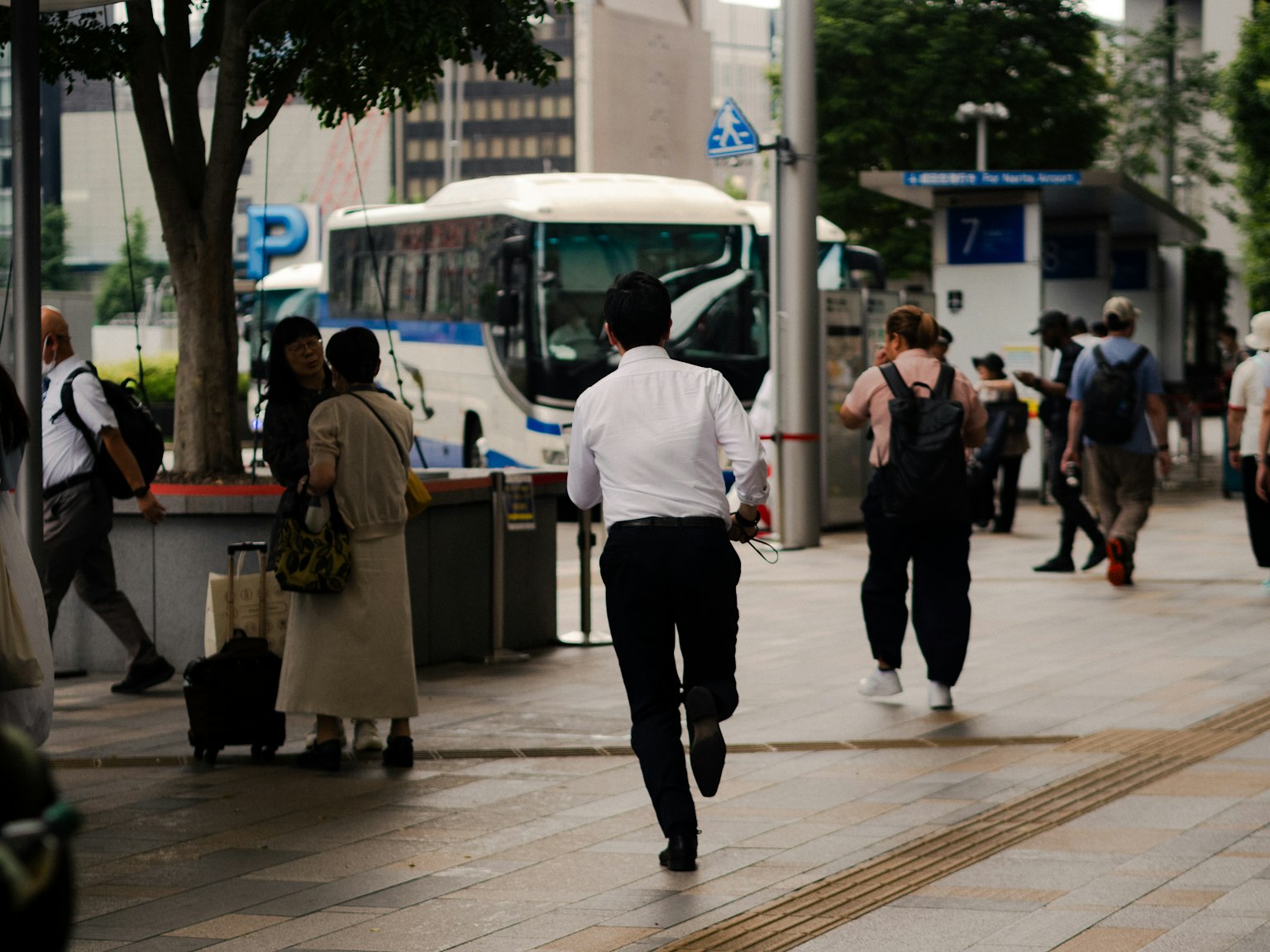城市景观，人们走动，公交车站和可见的公交车
