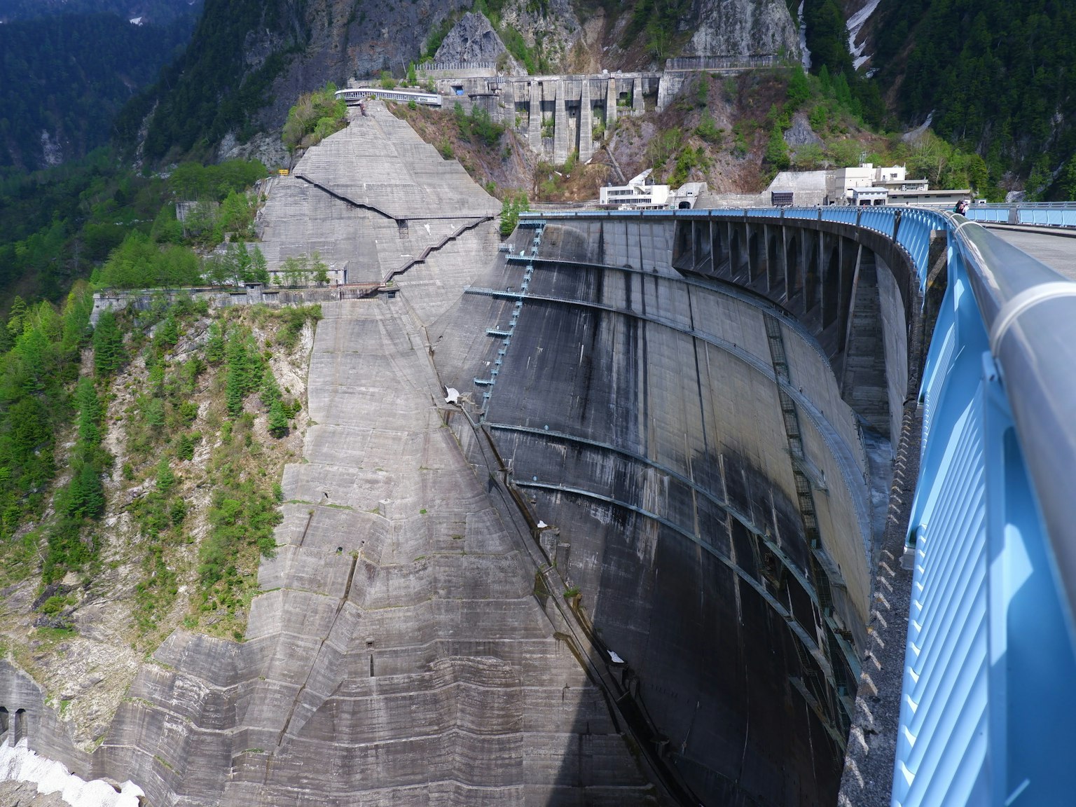 Vista del lato di una diga e delle montagne circostanti