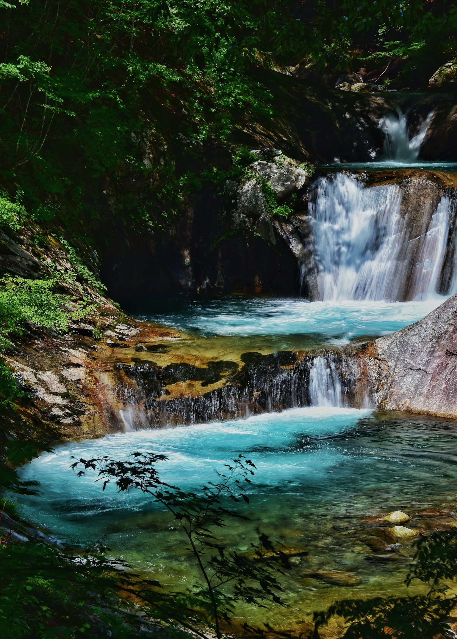 Pemandangan indah dengan air terjun biru dan kolam tenang