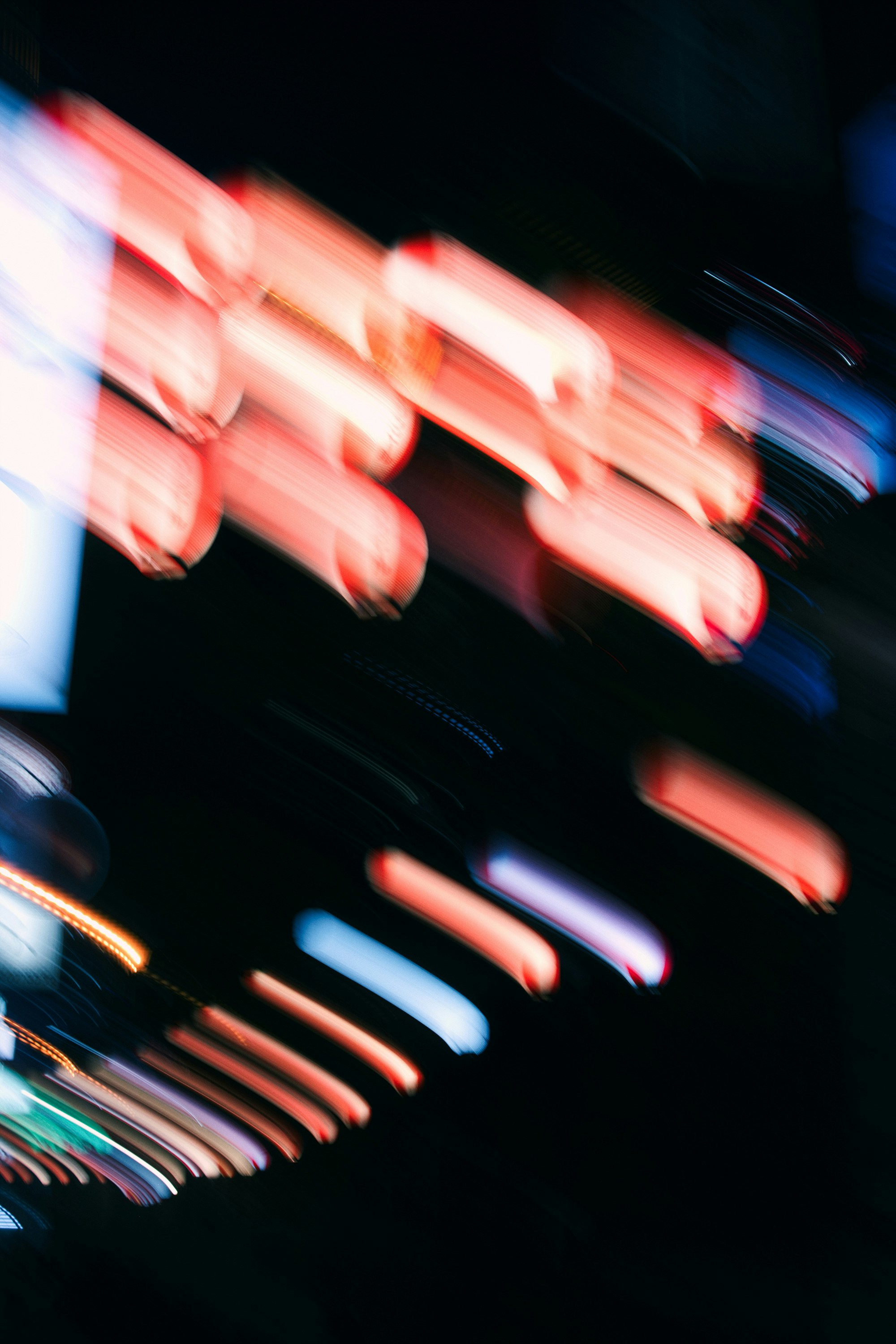 long-exposure red light trails and car headlights in a night street scene