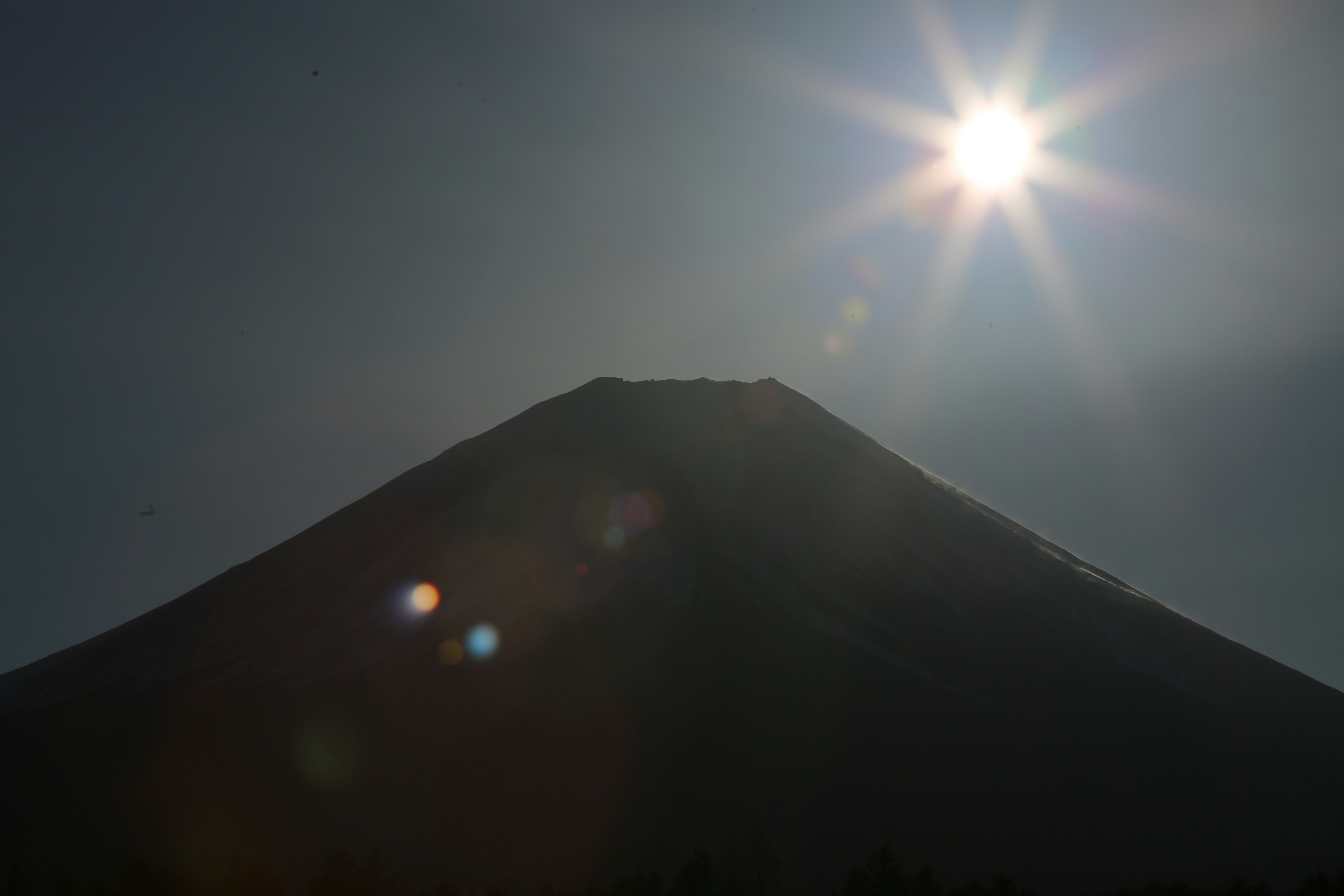 初日の出の光が差し込む山のシルエット