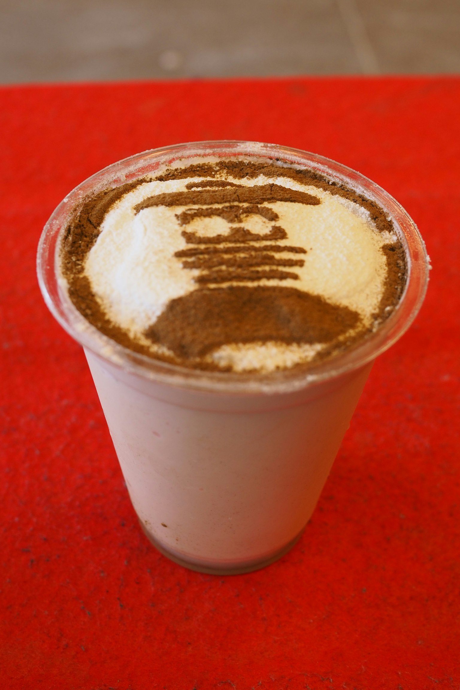 Bevanda dessert in un bicchiere con design artistico sopra