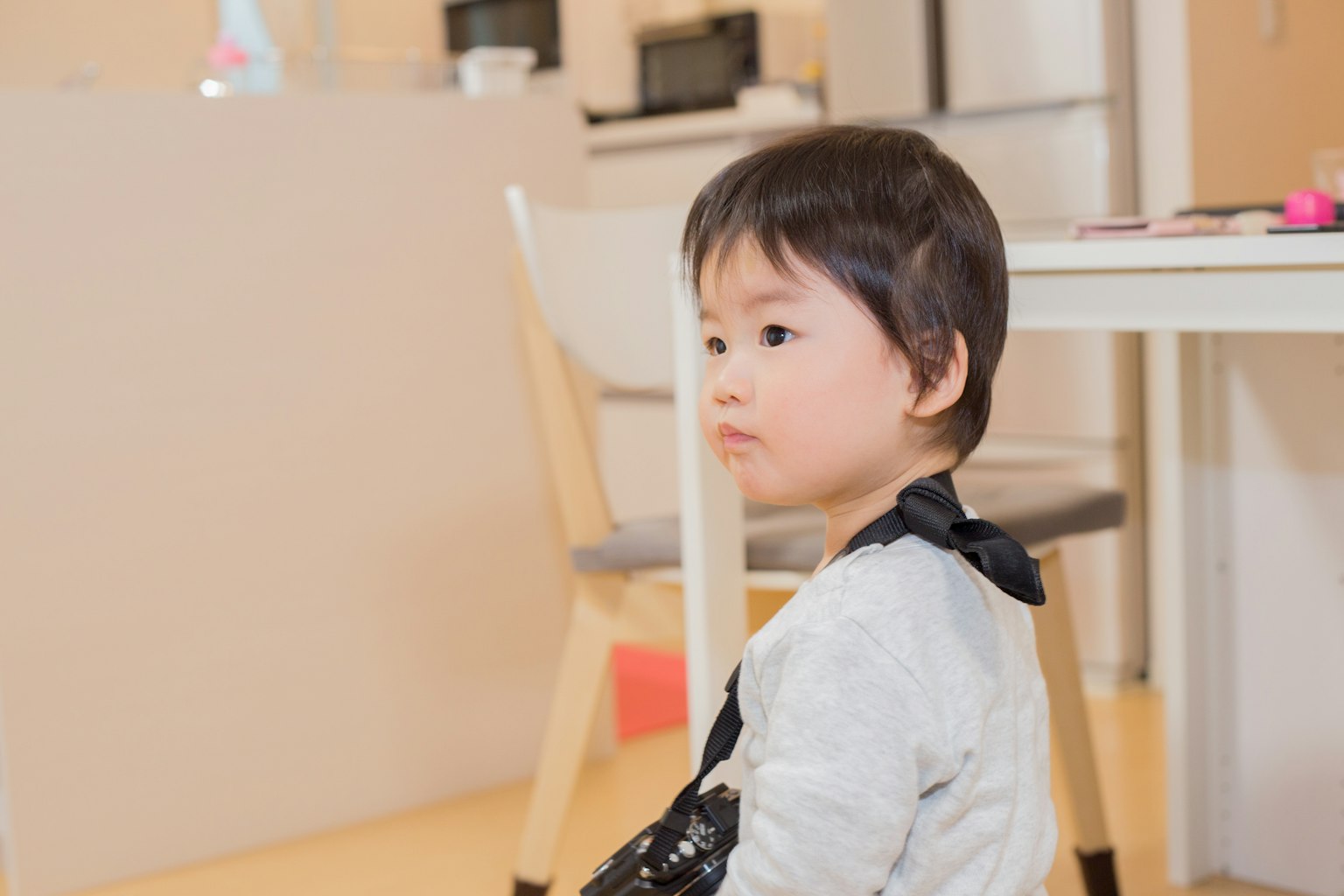 Niño sentado cerca de una mesa en una habitación