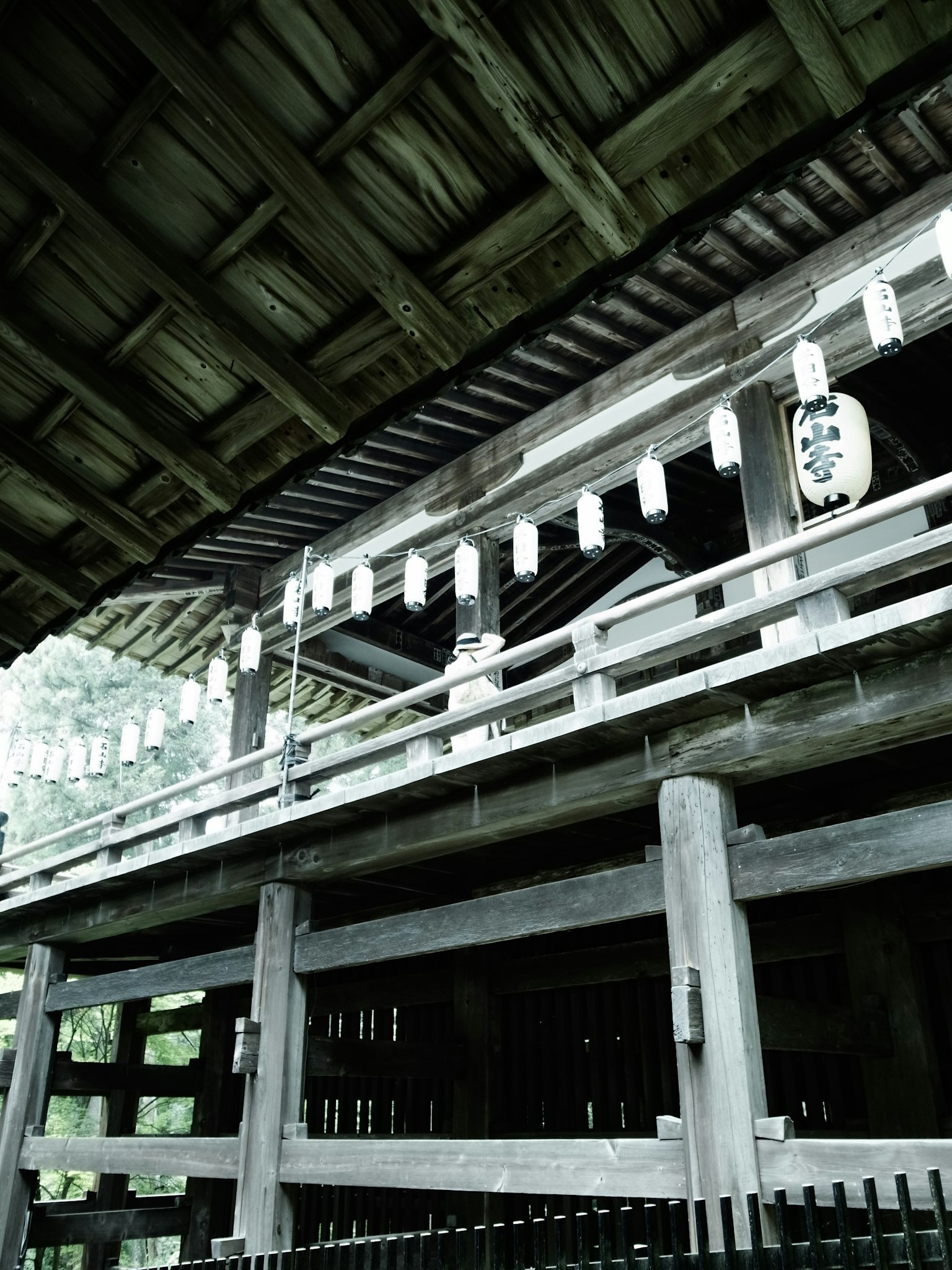 Innenansicht eines traditionellen japanischen Gebäudes mit Holzstruktur und Laternen