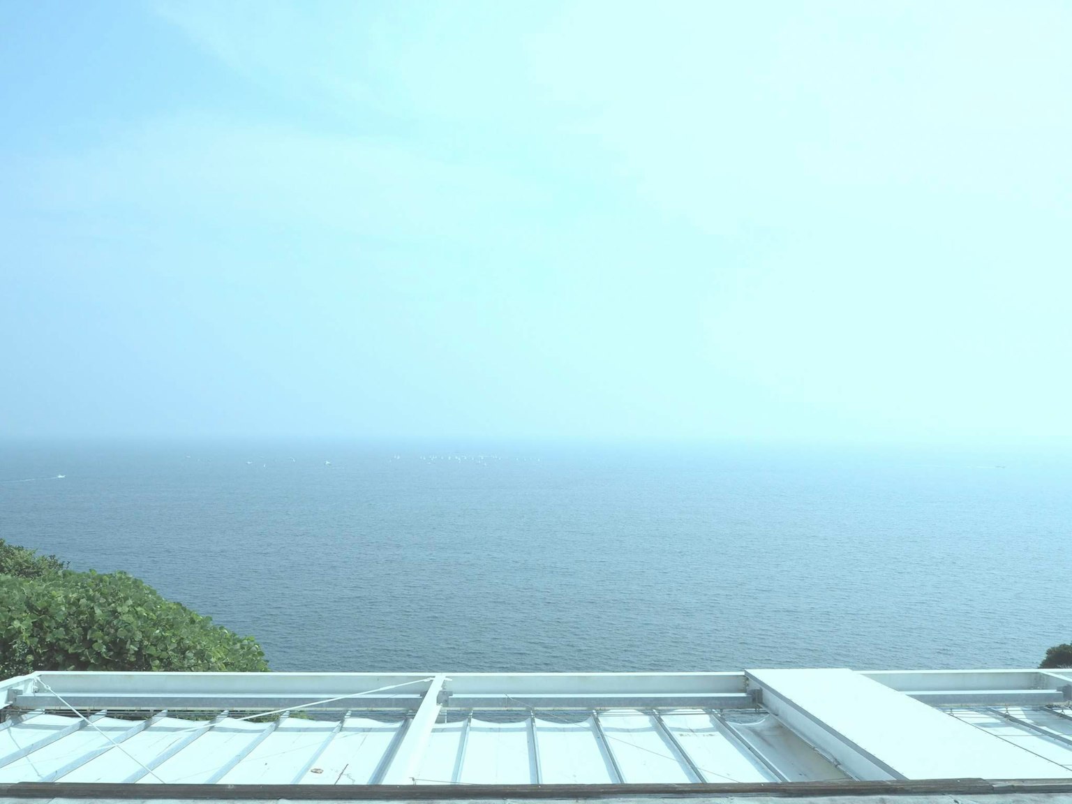 廣闊的藍色海洋在淡雲的天空下