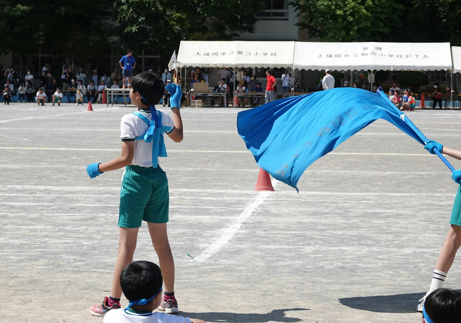 孩子們在運動會上揮舞藍色旗幟