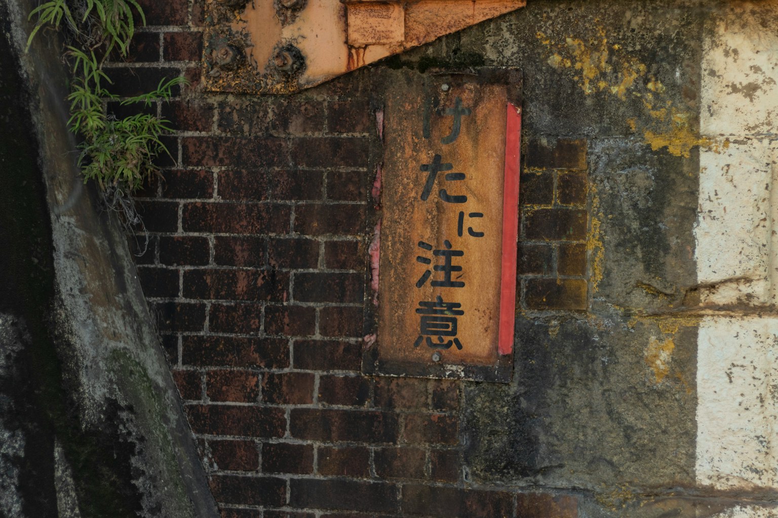 A warning sign hanging on an old brick wall