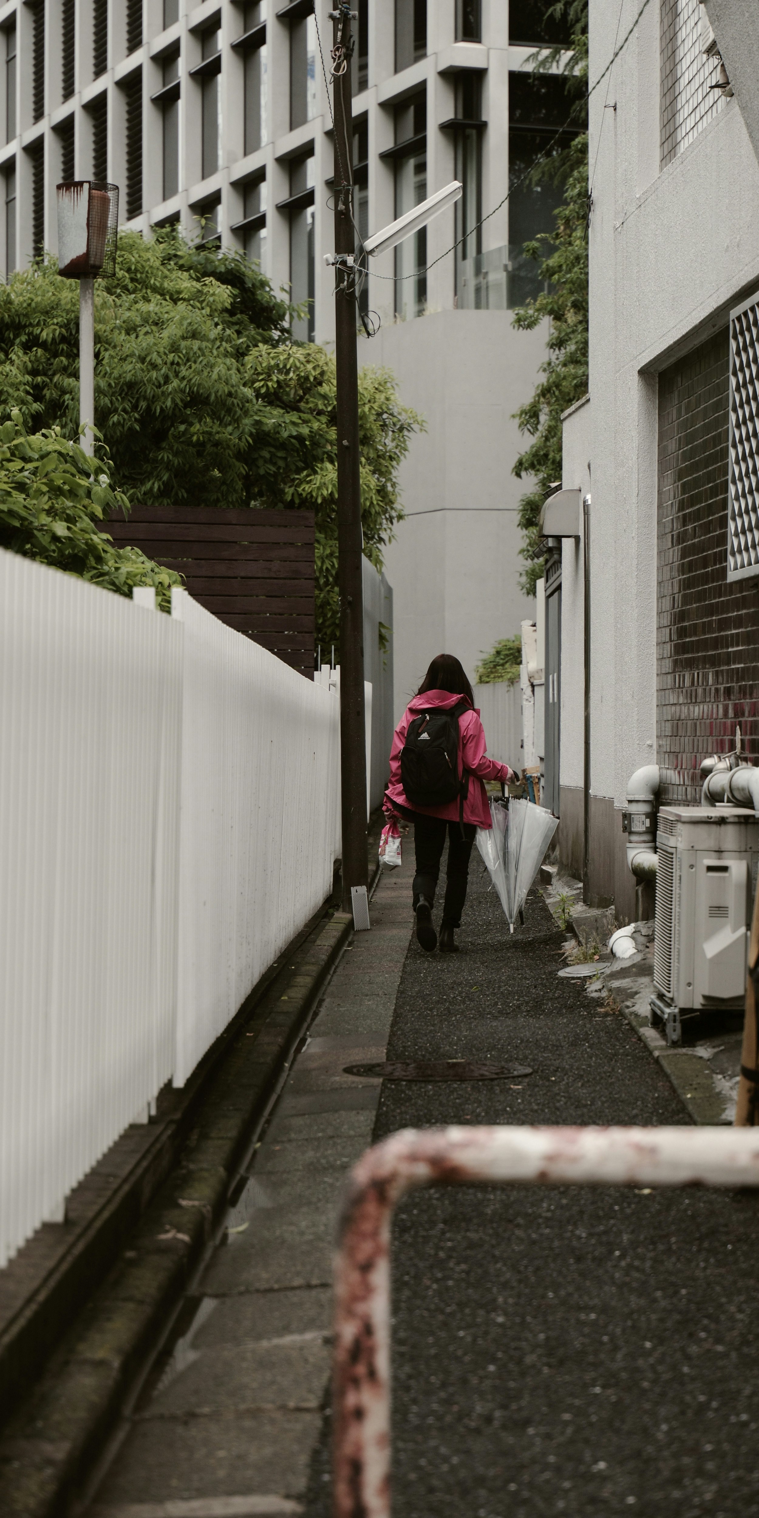 細い路地を歩く人と自転車のある東京の街並み