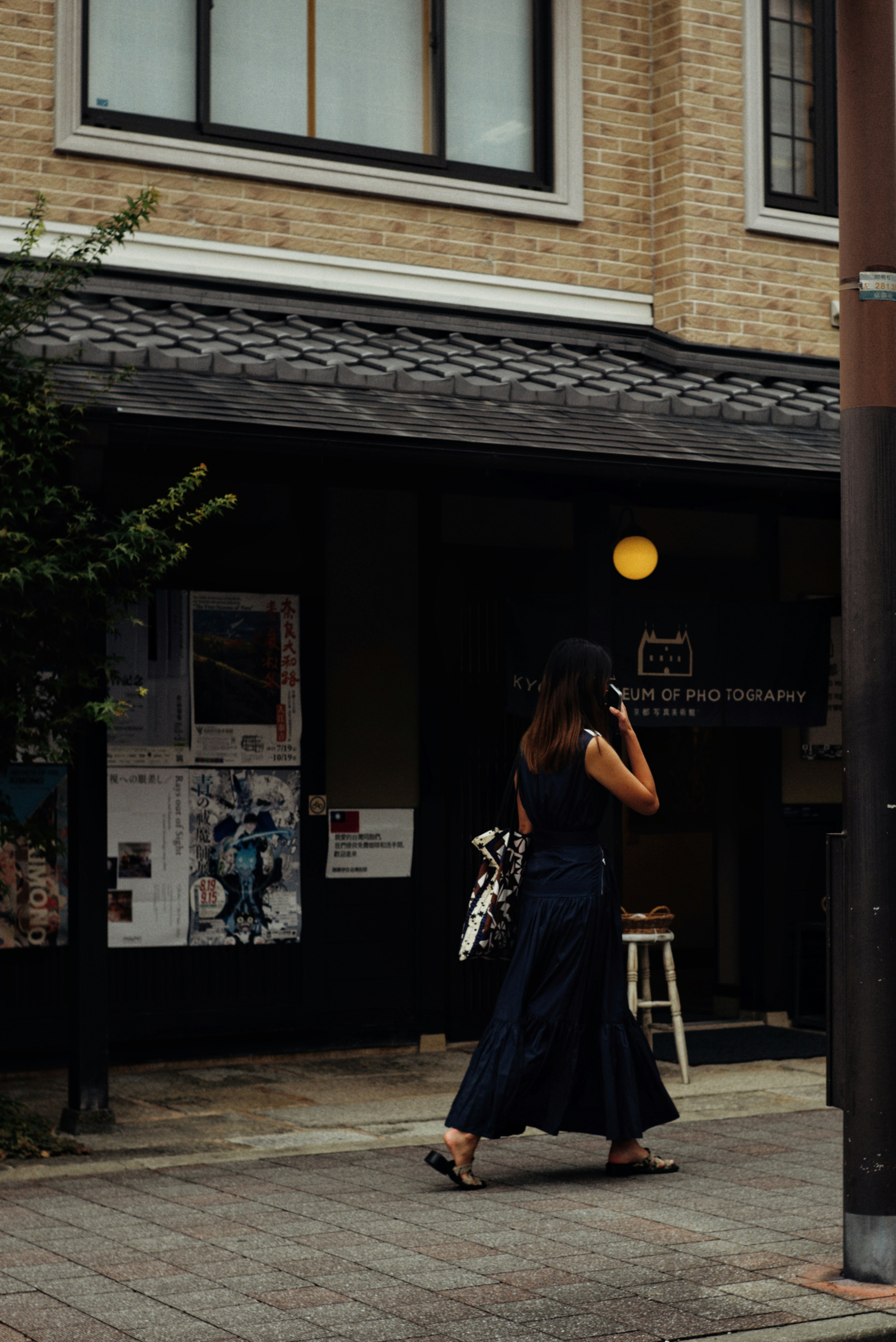 京都写真美術館の入口前で歩く人物