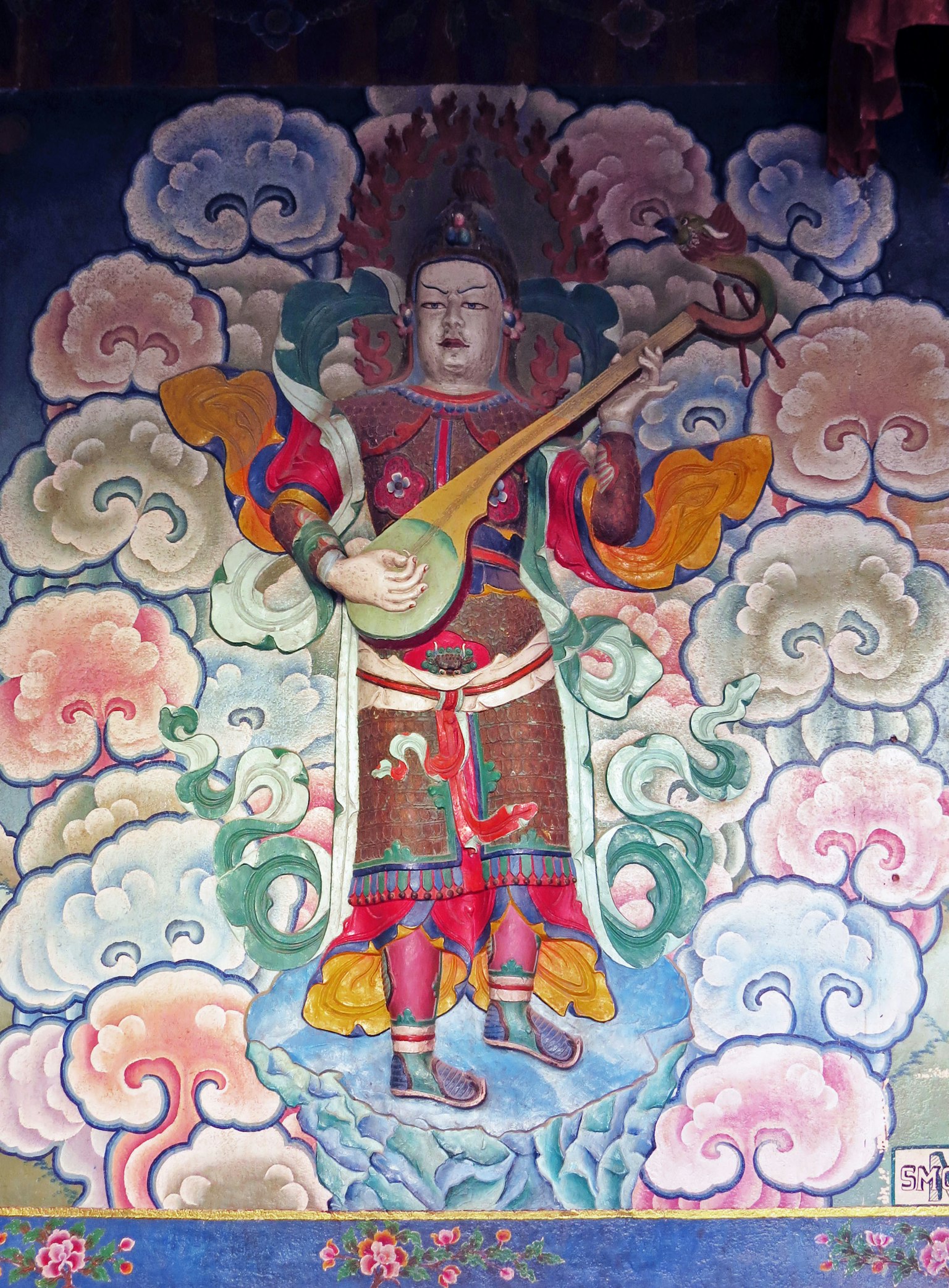 Une fresque d'une divinité tenant un instrument de musique entourée de nuages colorés