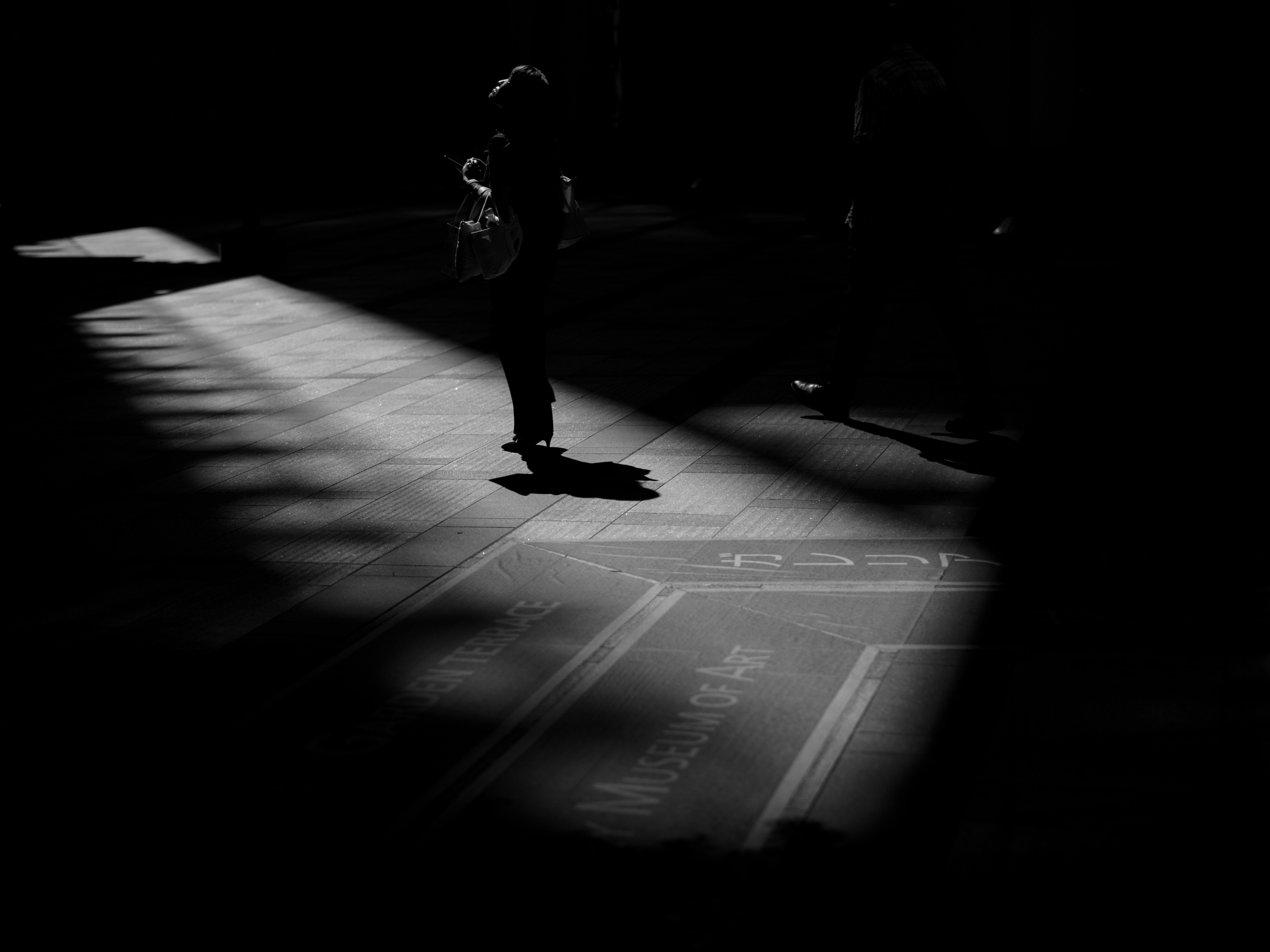 暗い路地を歩く人物のシルエットと影