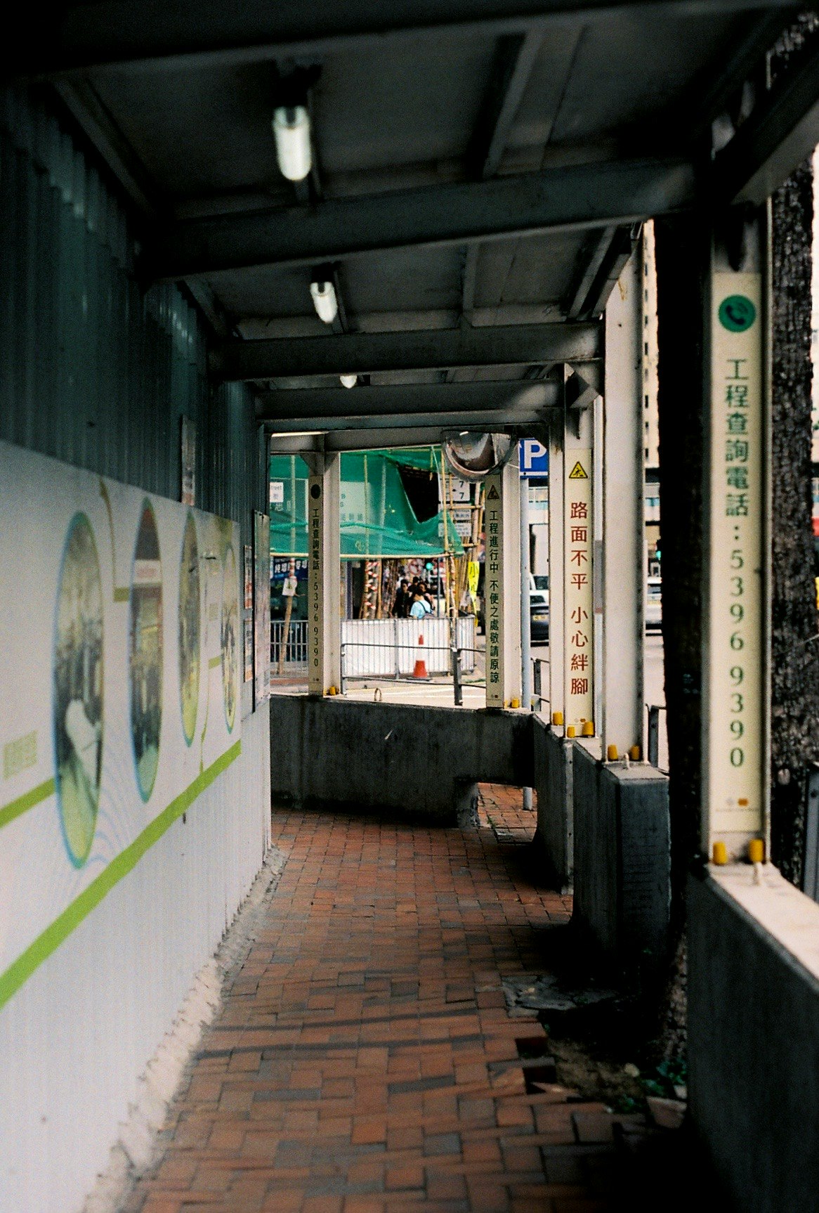 路地の壁に描かれたグラフィティと細い通路のある商店街の軒先