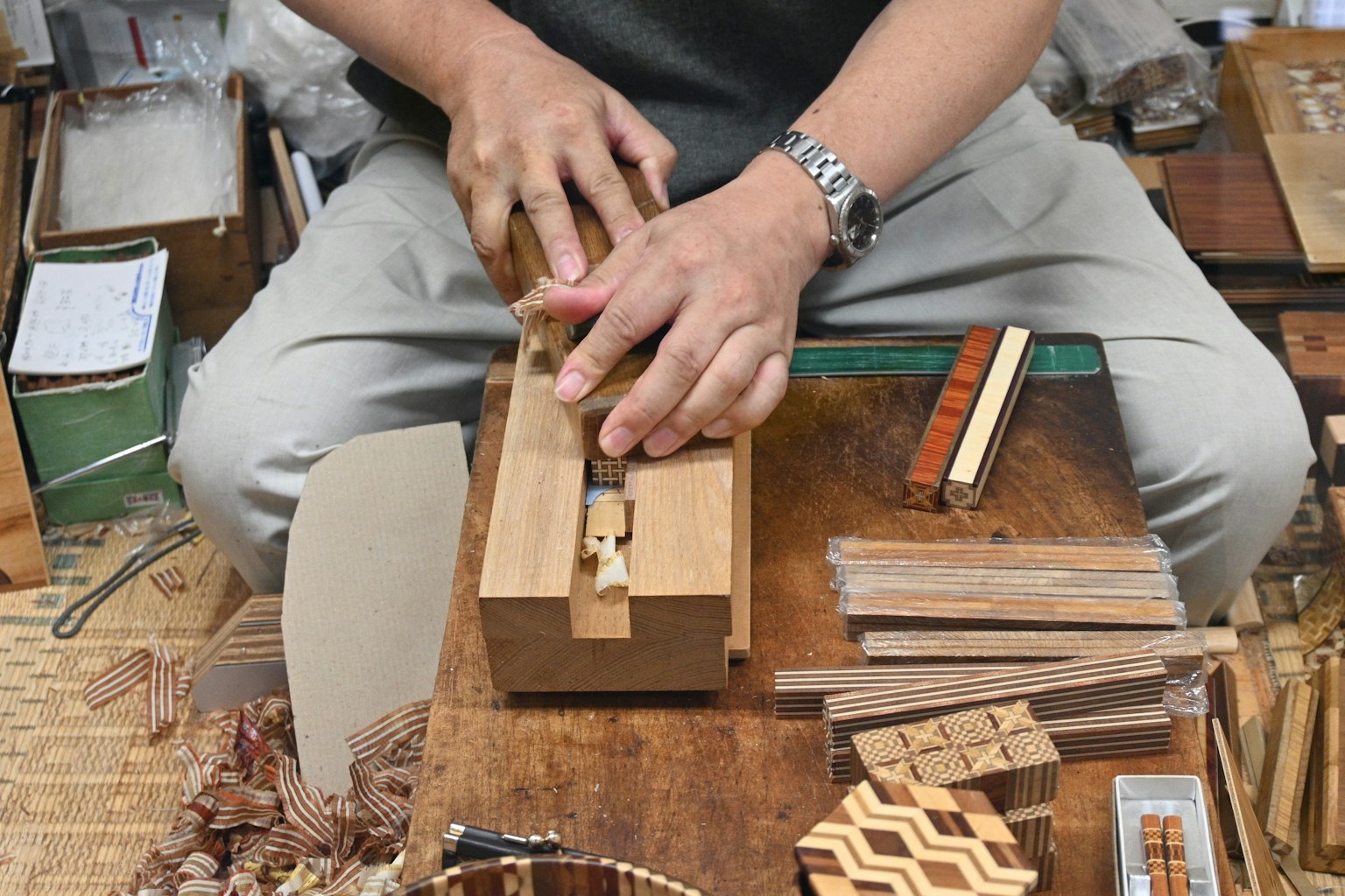 Un carpintero dando forma a la madera con un cepillo de mano