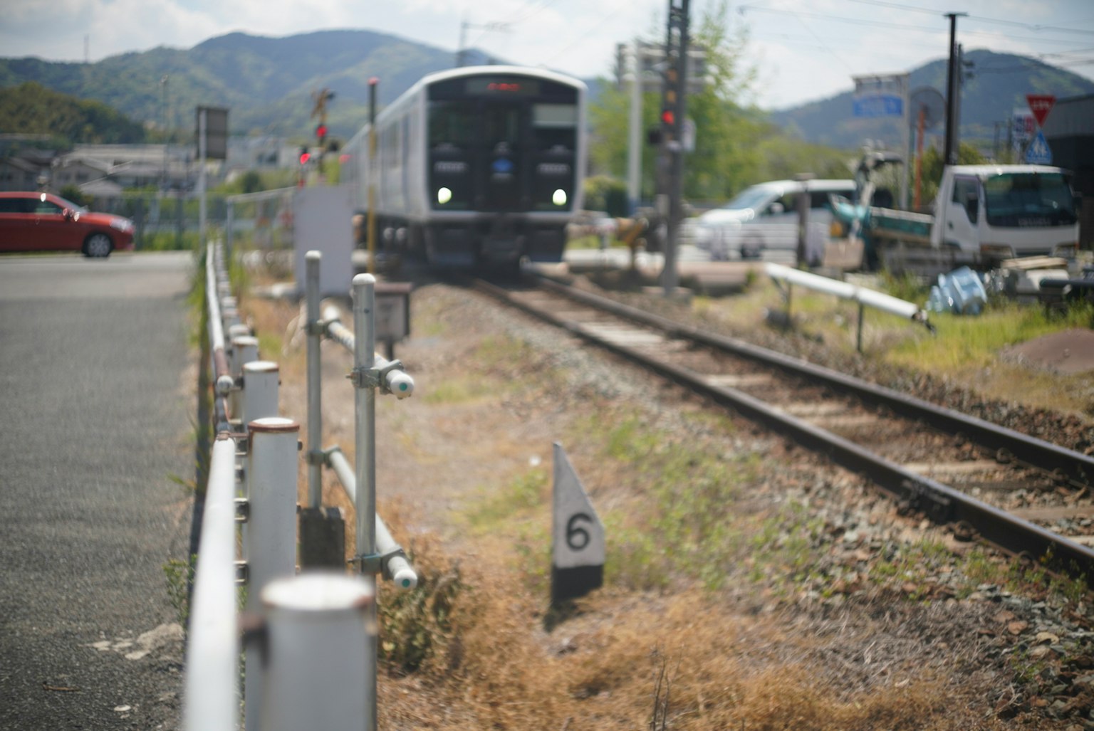 Tren acercándose en un paisaje ferroviario con señalización