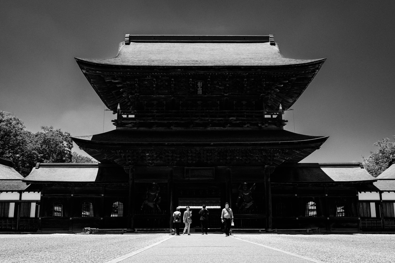 Imagen en blanco y negro de un edificio de templo histórico con personas en primer plano