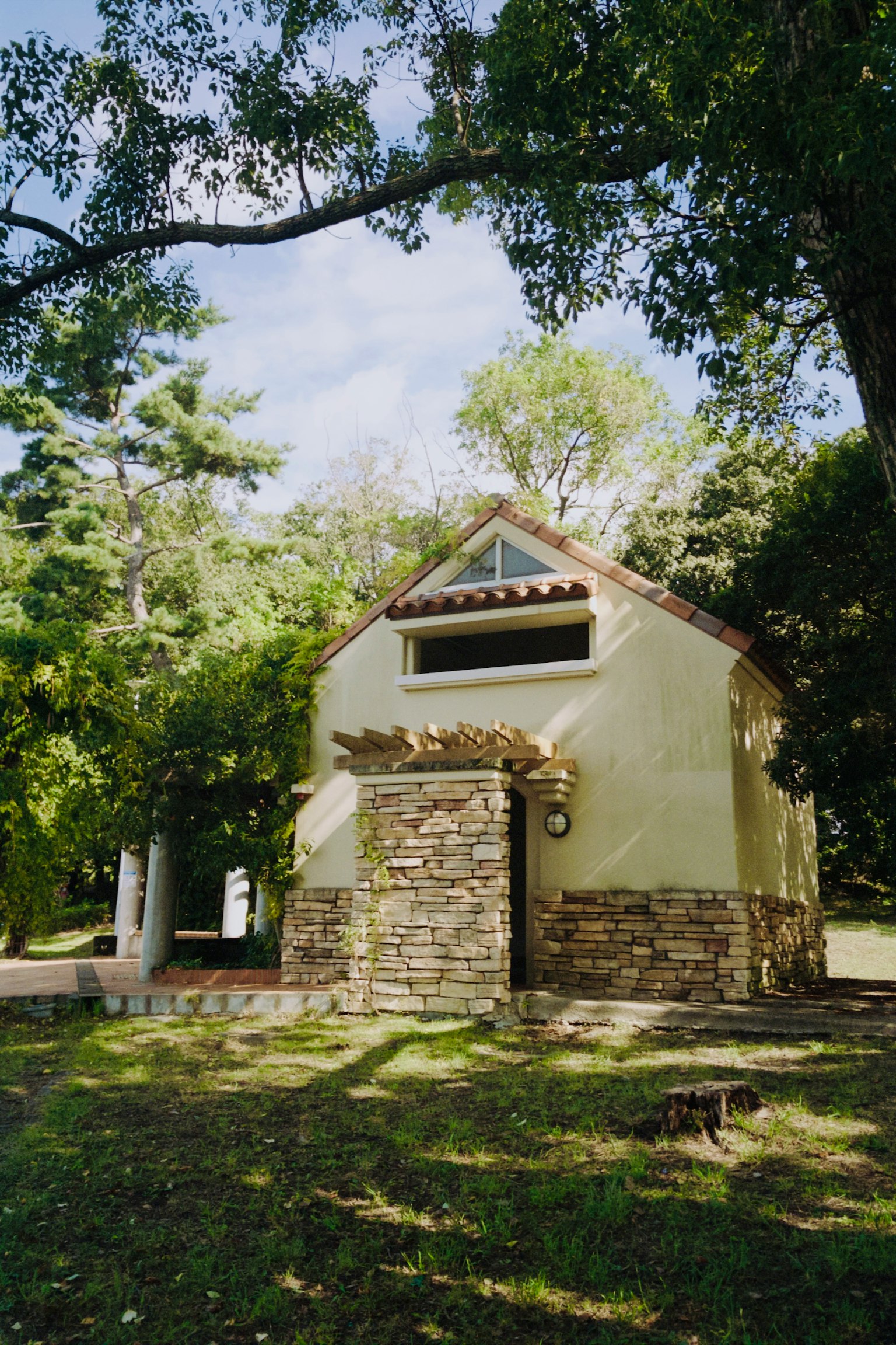 小さな家の外観が見える緑豊かな環境にある石造りの壁と屋根の家