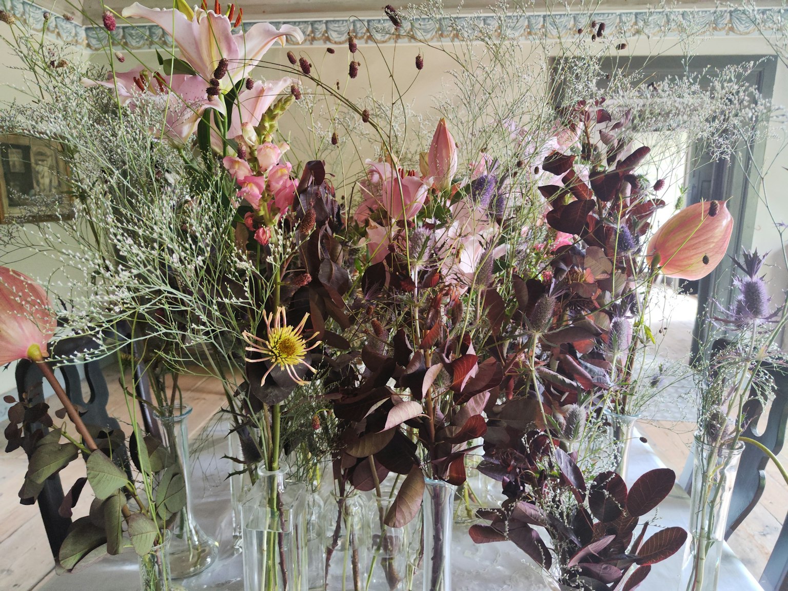 Bunte Anordnung von Trockenblumen in Glasvasen