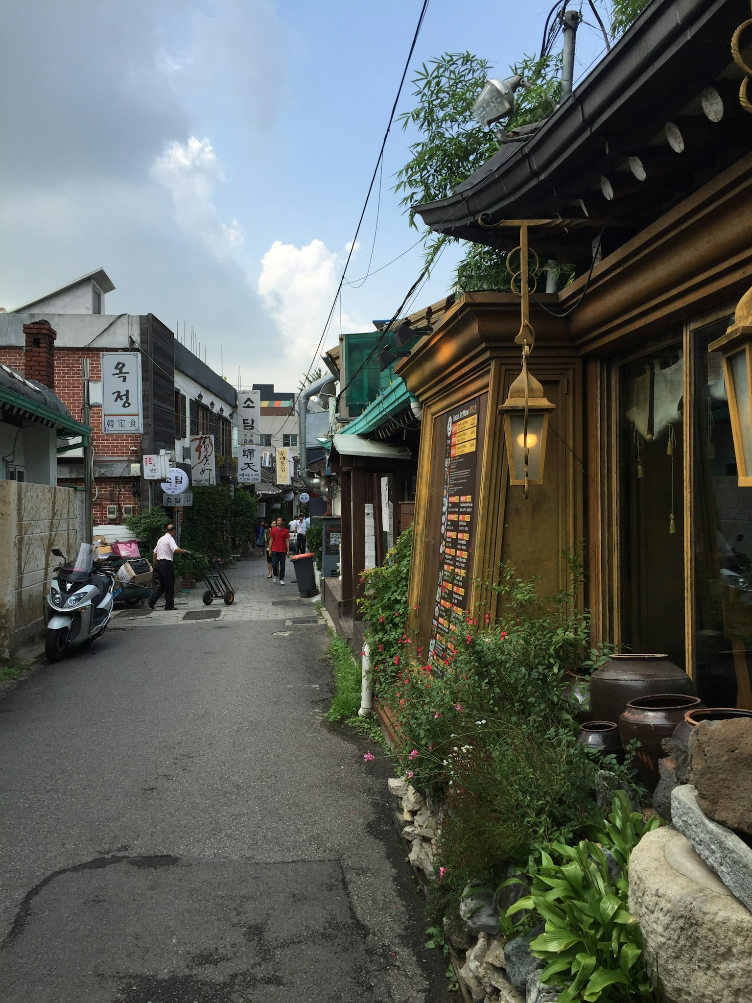 Charmante ruelle avec une architecture en bois traditionnel et une végétation luxuriante en Corée