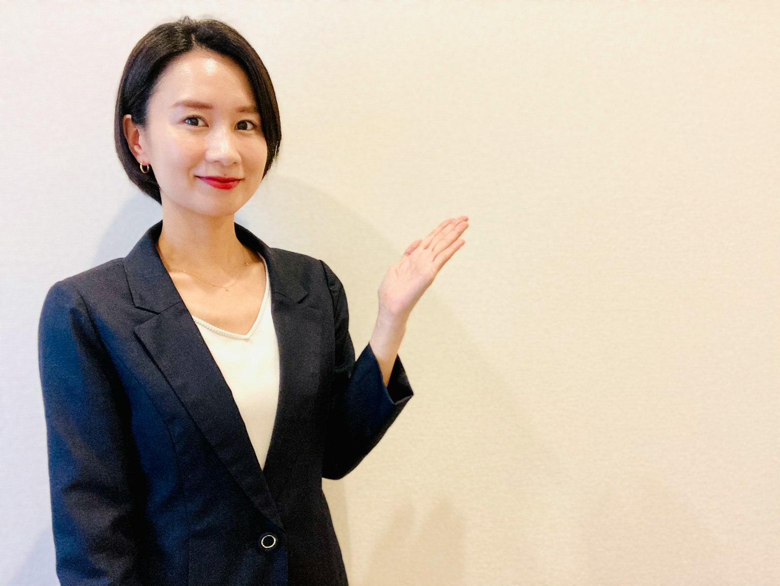 Một người phụ nữ trong bộ đồ vest giơ tay phải ra ngoài