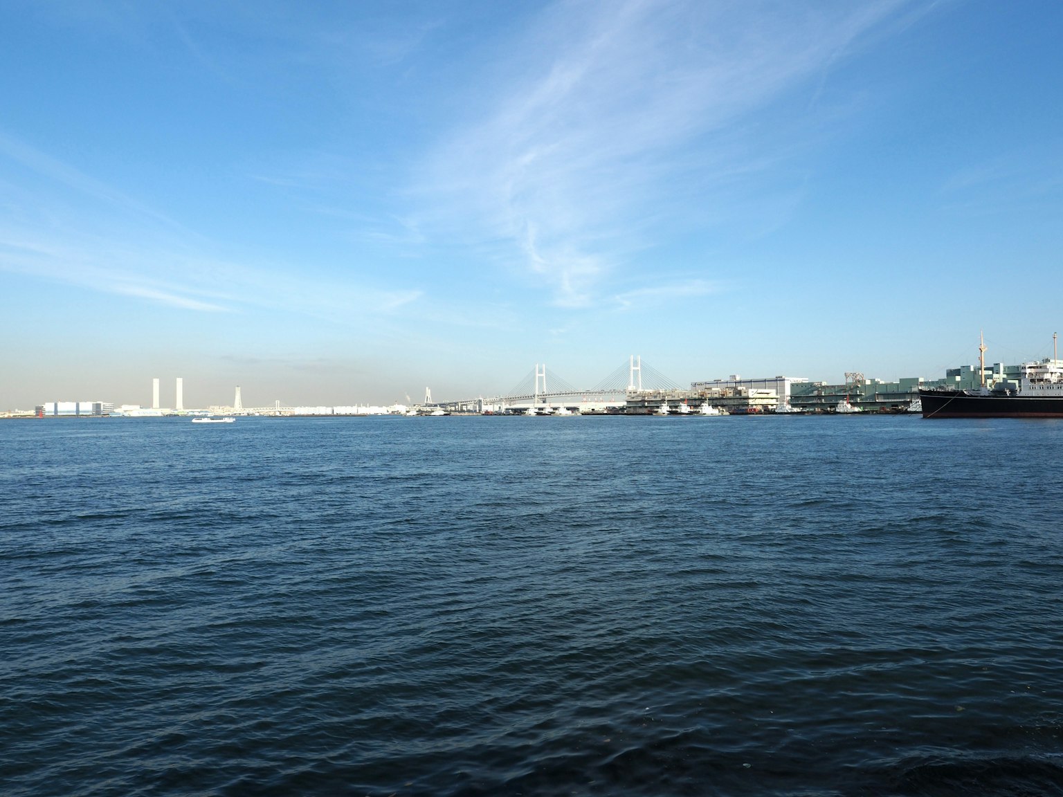 藍天下寧靜海面的風景，港口建築可見