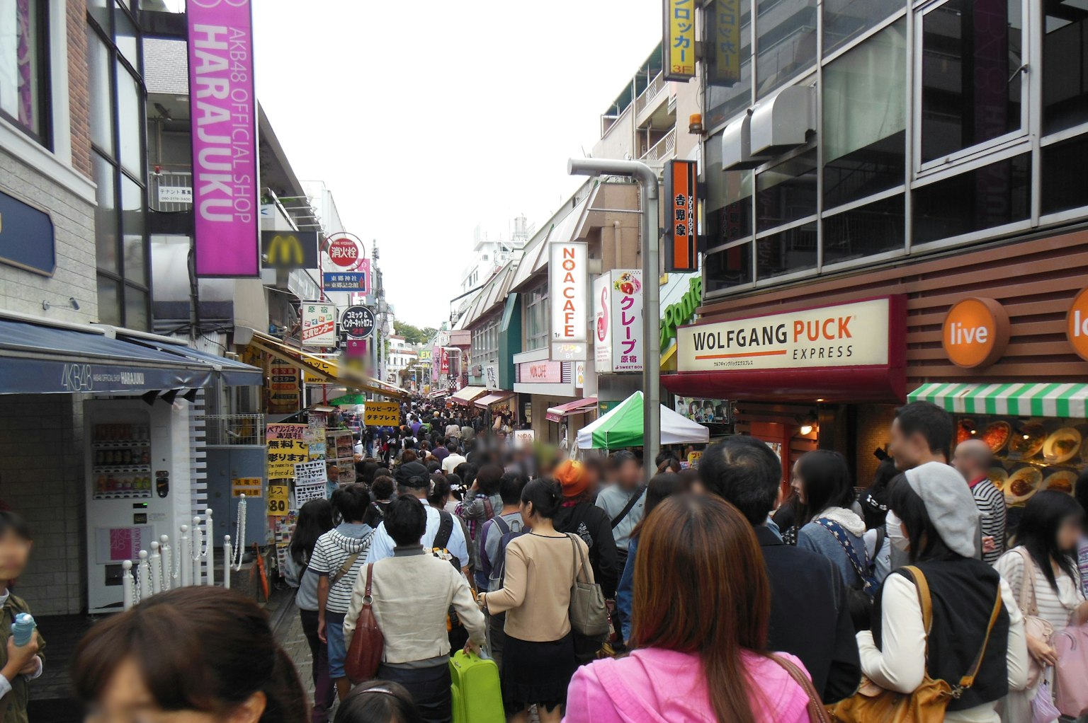 Strada affollata a Harajuku con persone e negozi