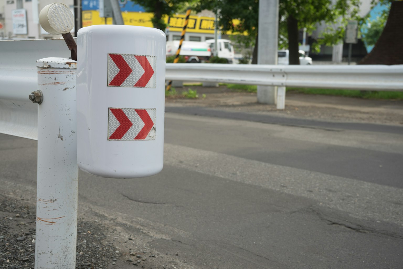 White guardrail with red arrow markings