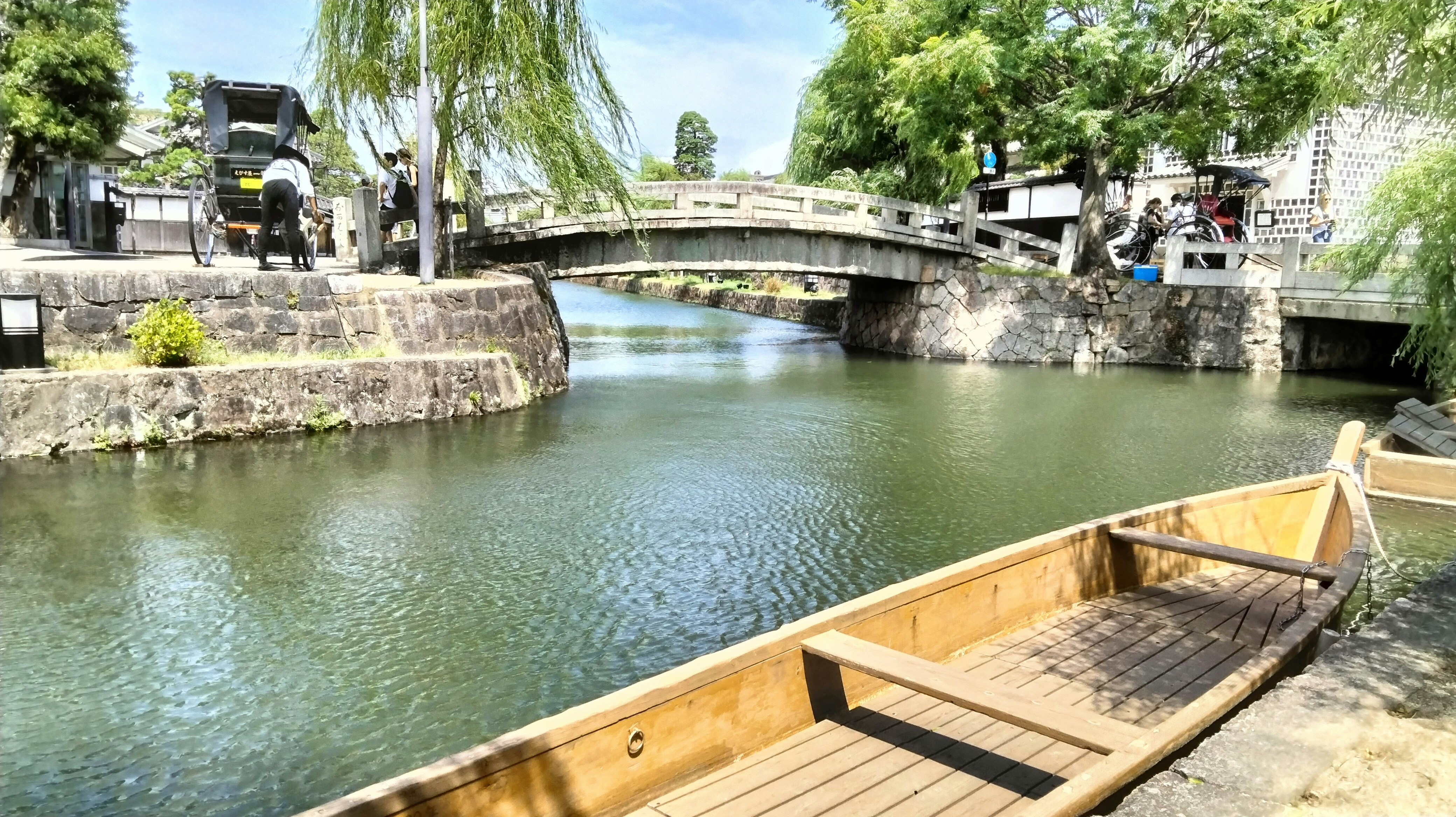 運河沿いの石造りの橋と小舟が並ぶ水辺の風景