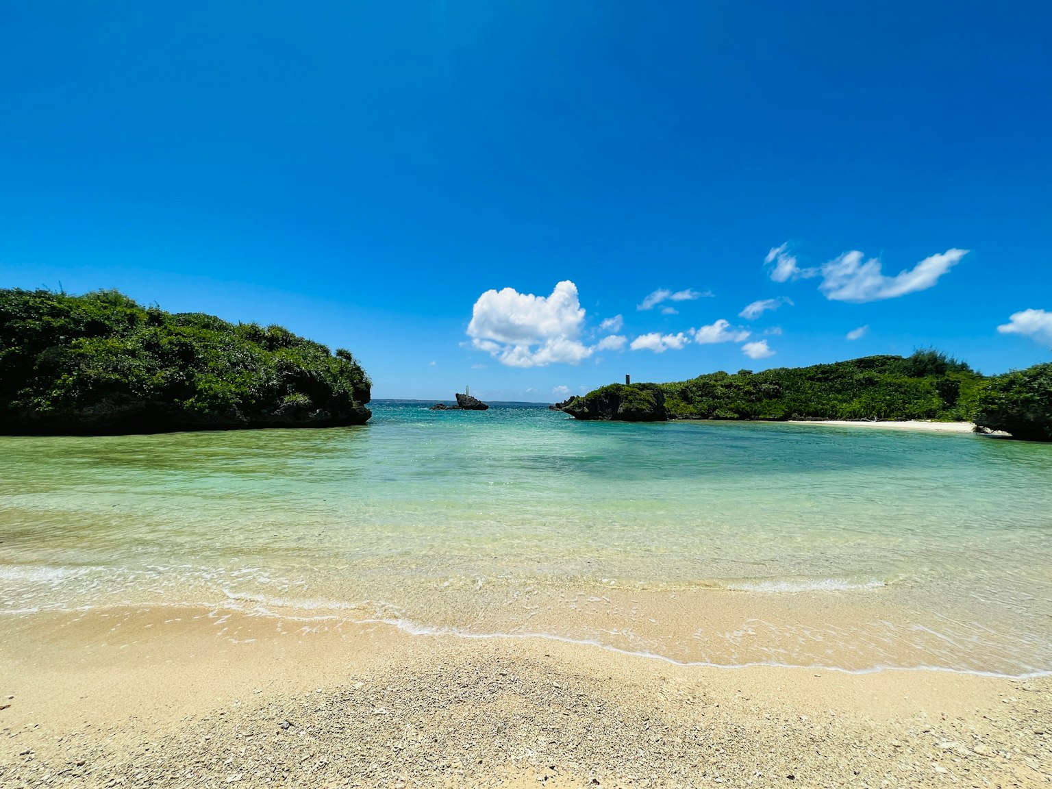 Bellissima scena di spiaggia con mare blu colline verdi e spiaggia di sabbia bianca