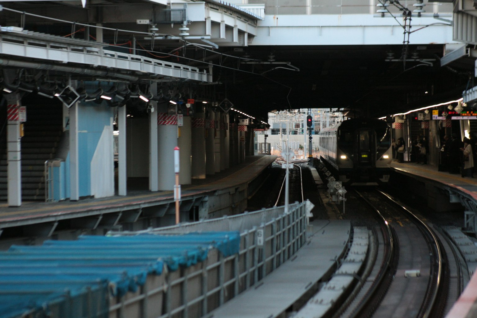 火車駛入黑暗隧道，平台和軌道可見