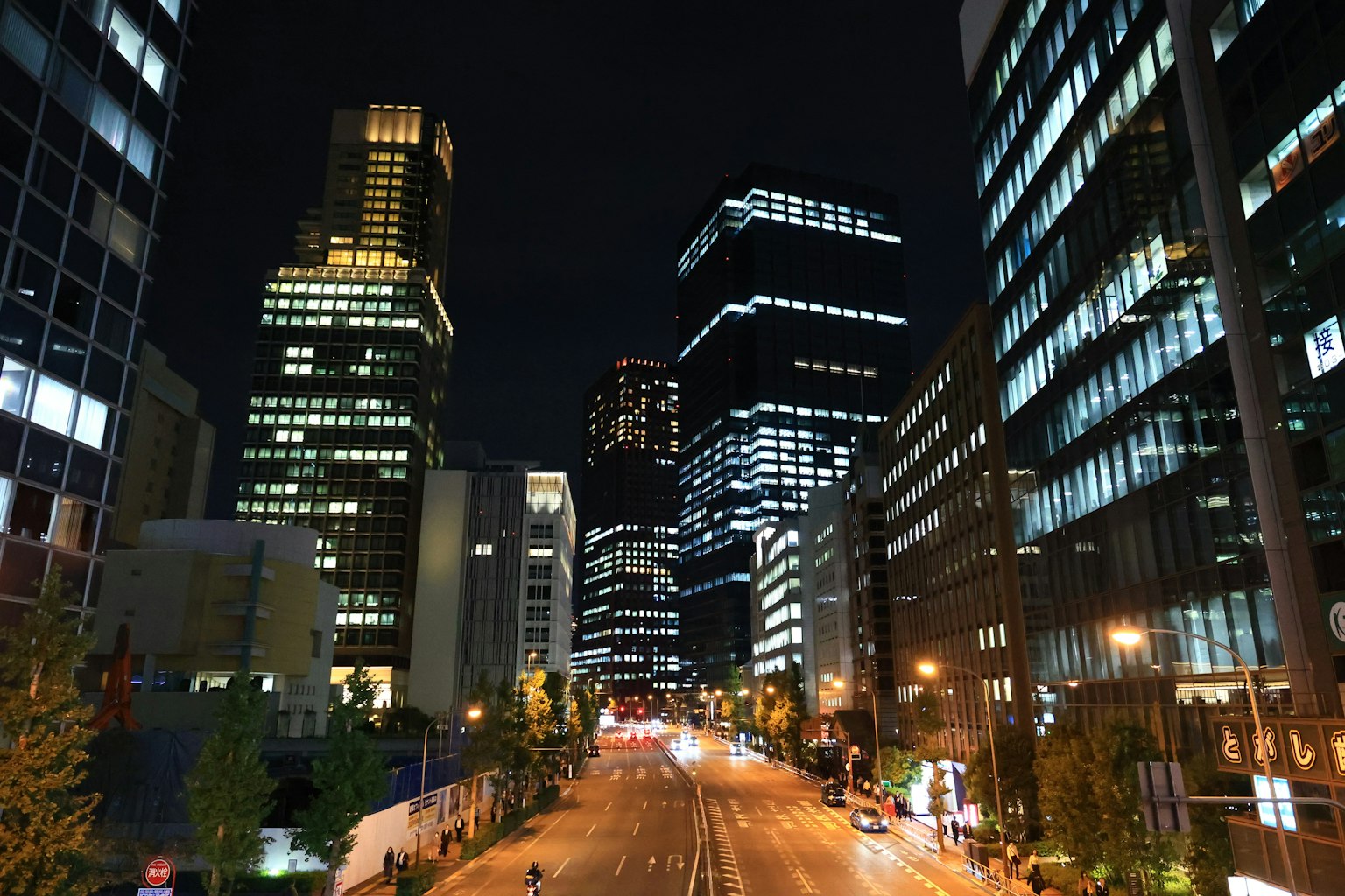 Nächtliche Stadtlandschaft mit Wolkenkratzern entlang einer Straße