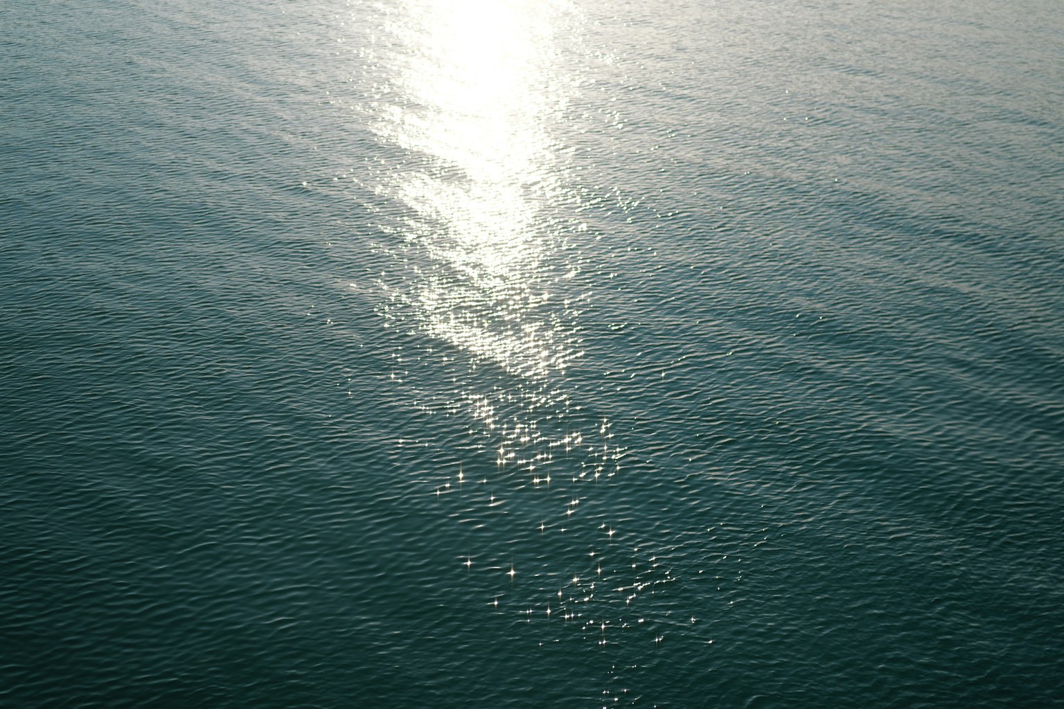 Lumière du soleil scintillante se reflétant sur la surface des vagues calmes de l'océan