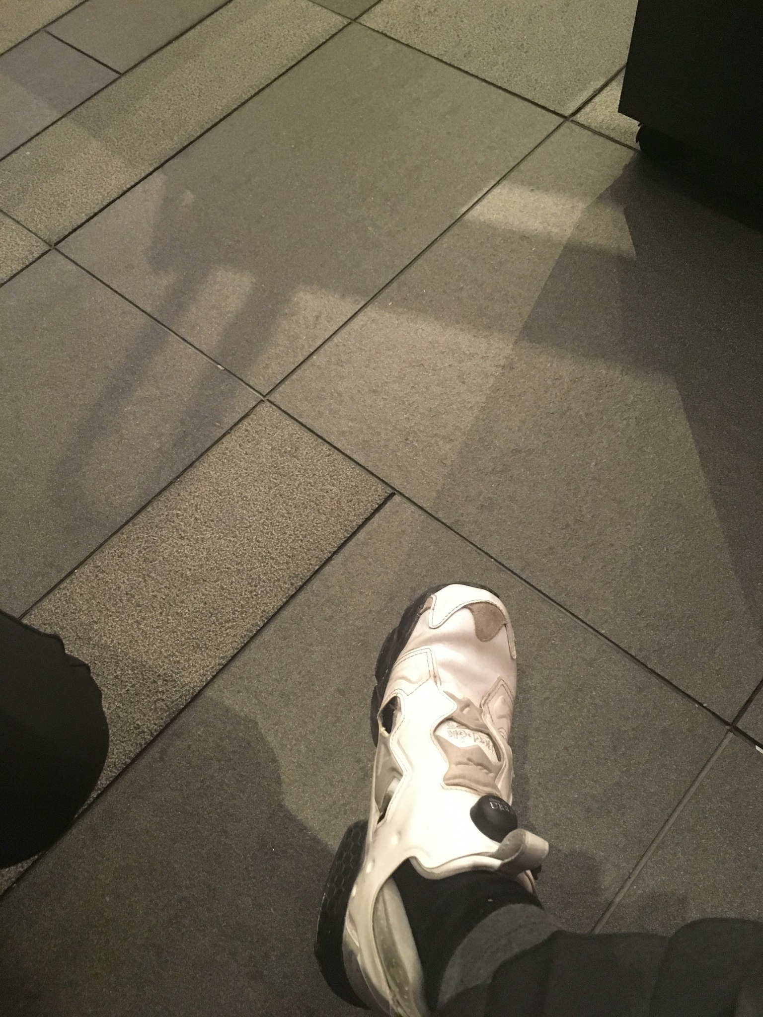 Một đôi sneaker trắng trên nền gạch