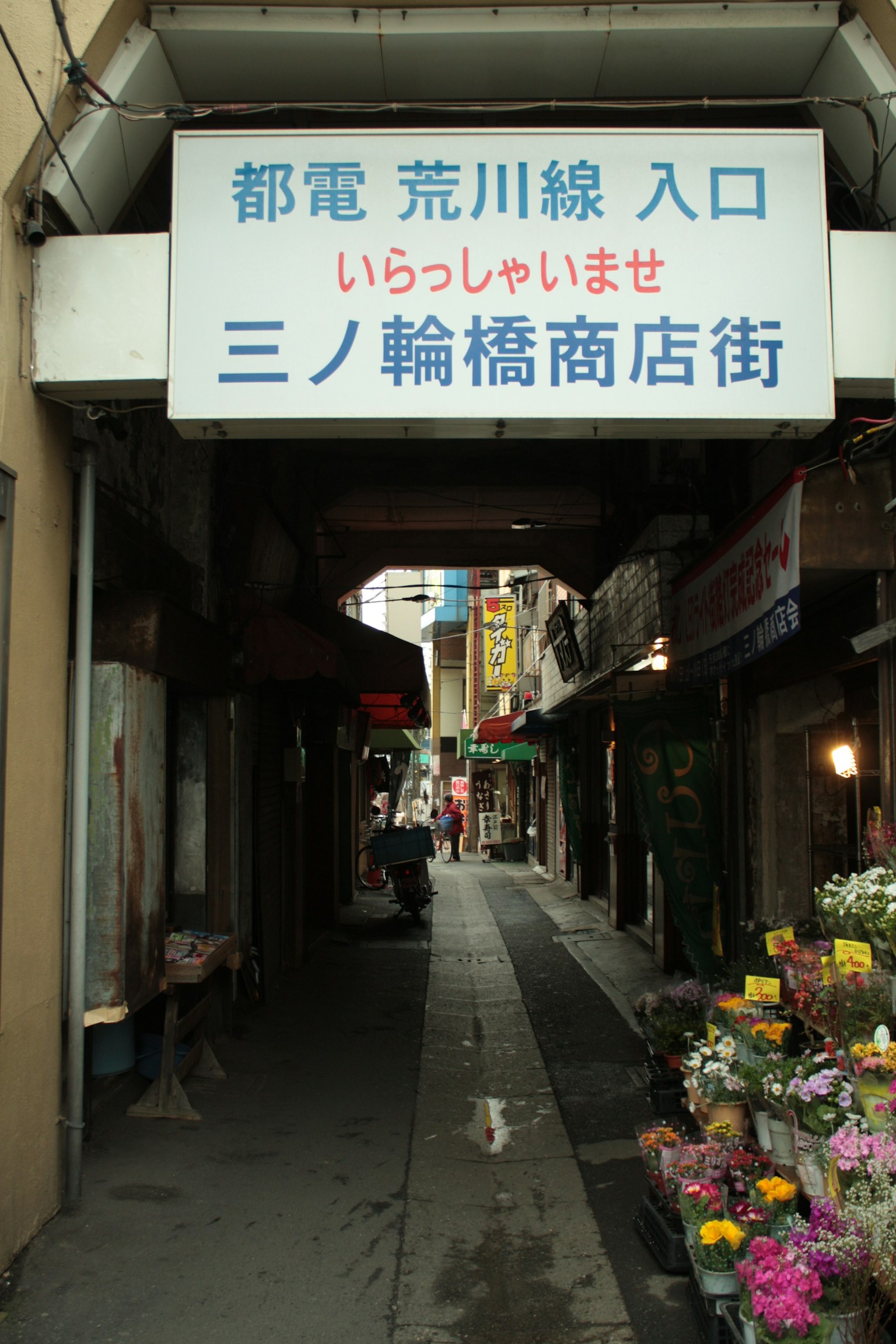指示荒川线入口的标志和街道上的商店