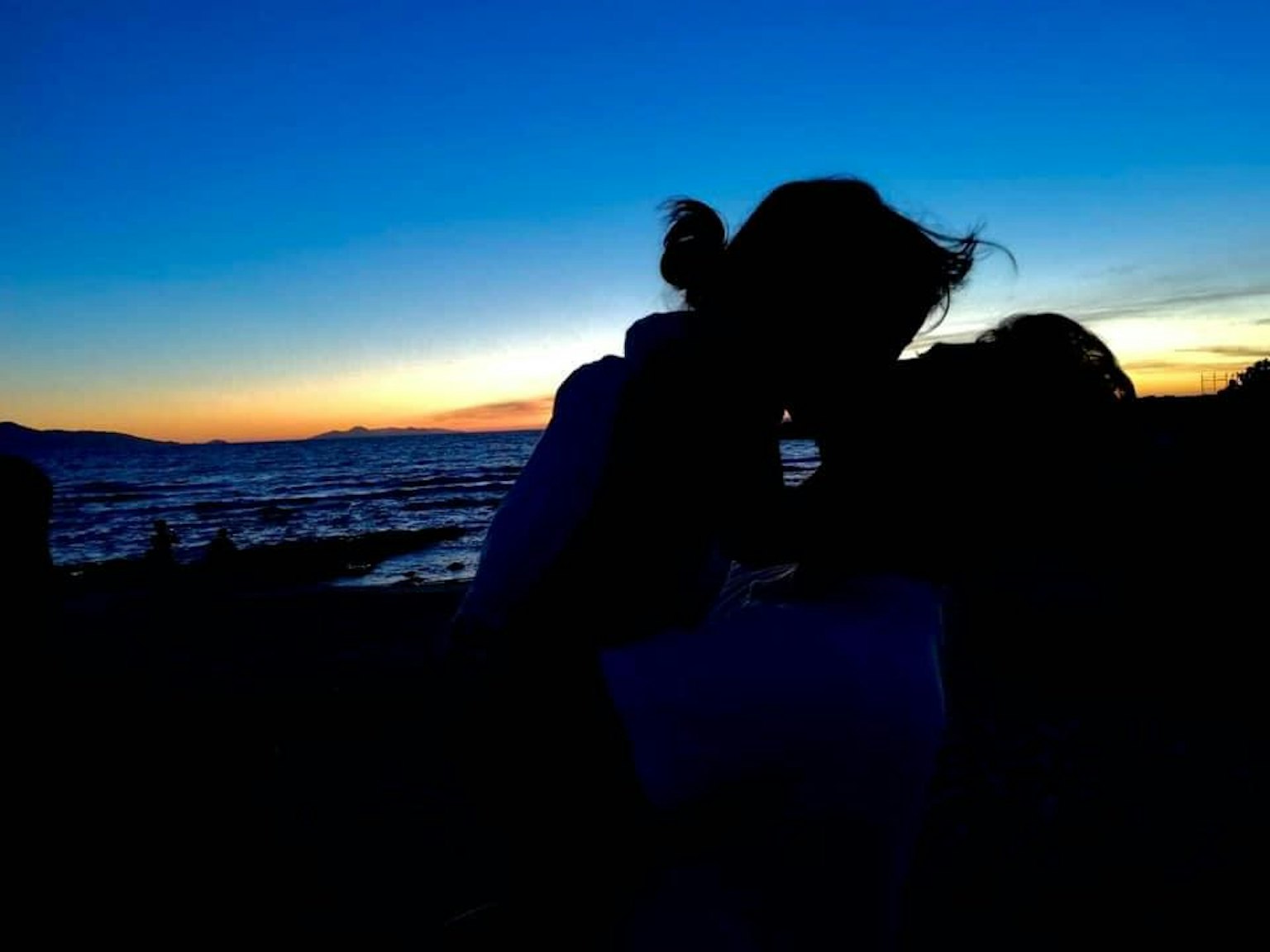 Silhouette di una coppia che si bacia al tramonto