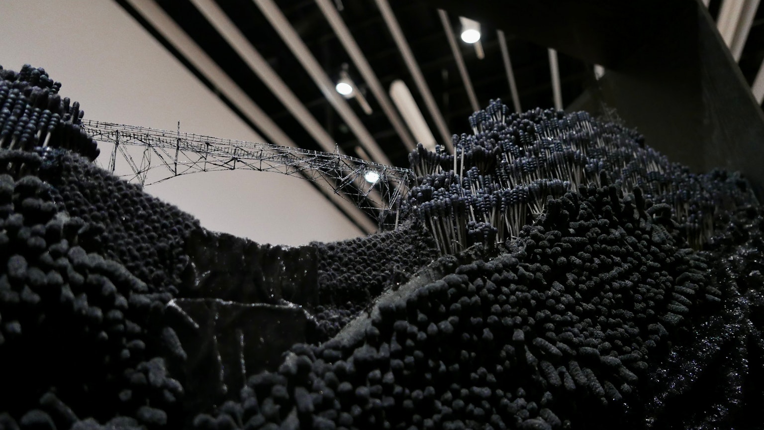 Gros plan d'une sculpture en sphères noires avec un design de plafond linéaire