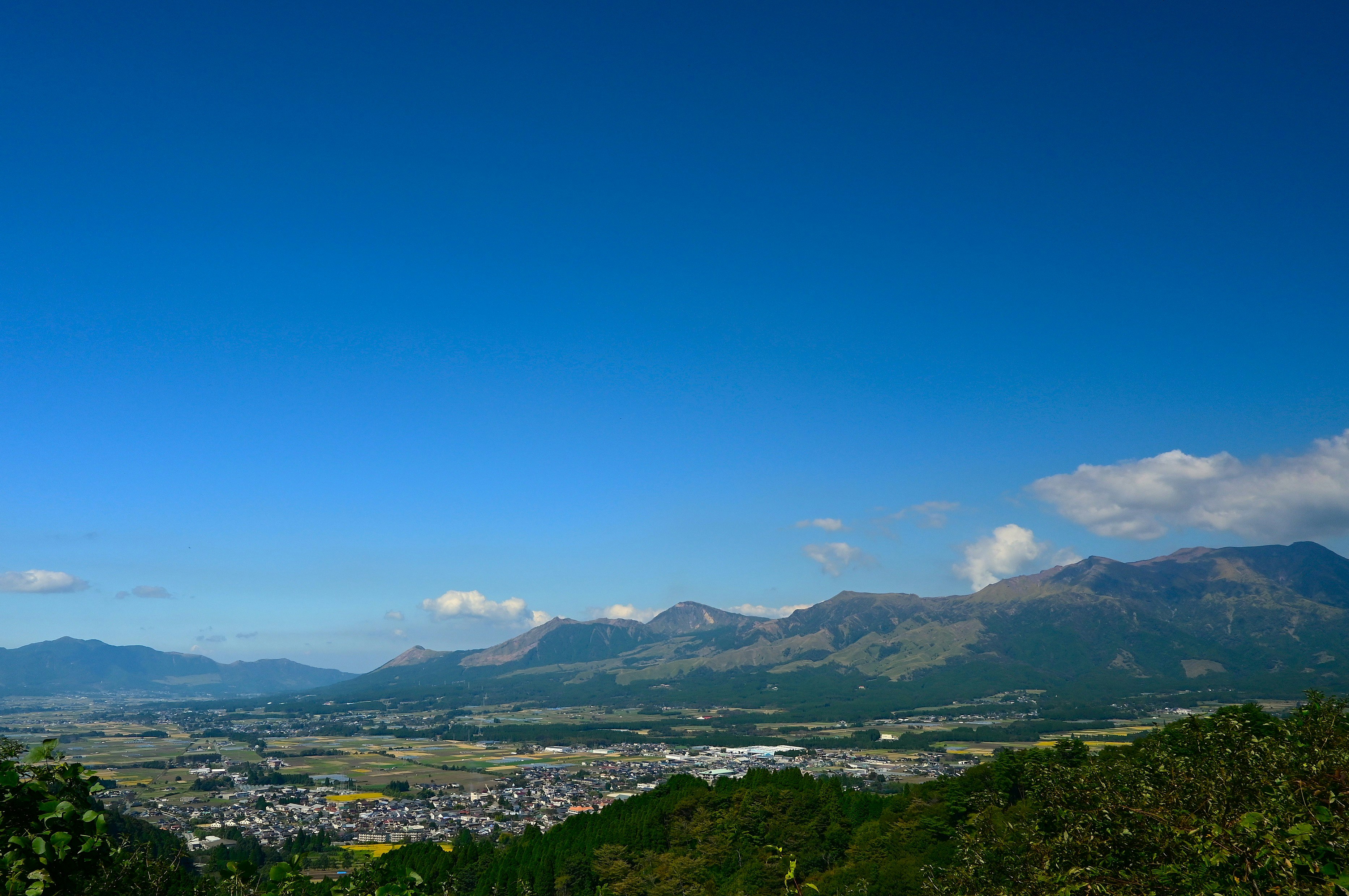 阿蘇の山並みと街並みを見下ろす大パノラマの風景