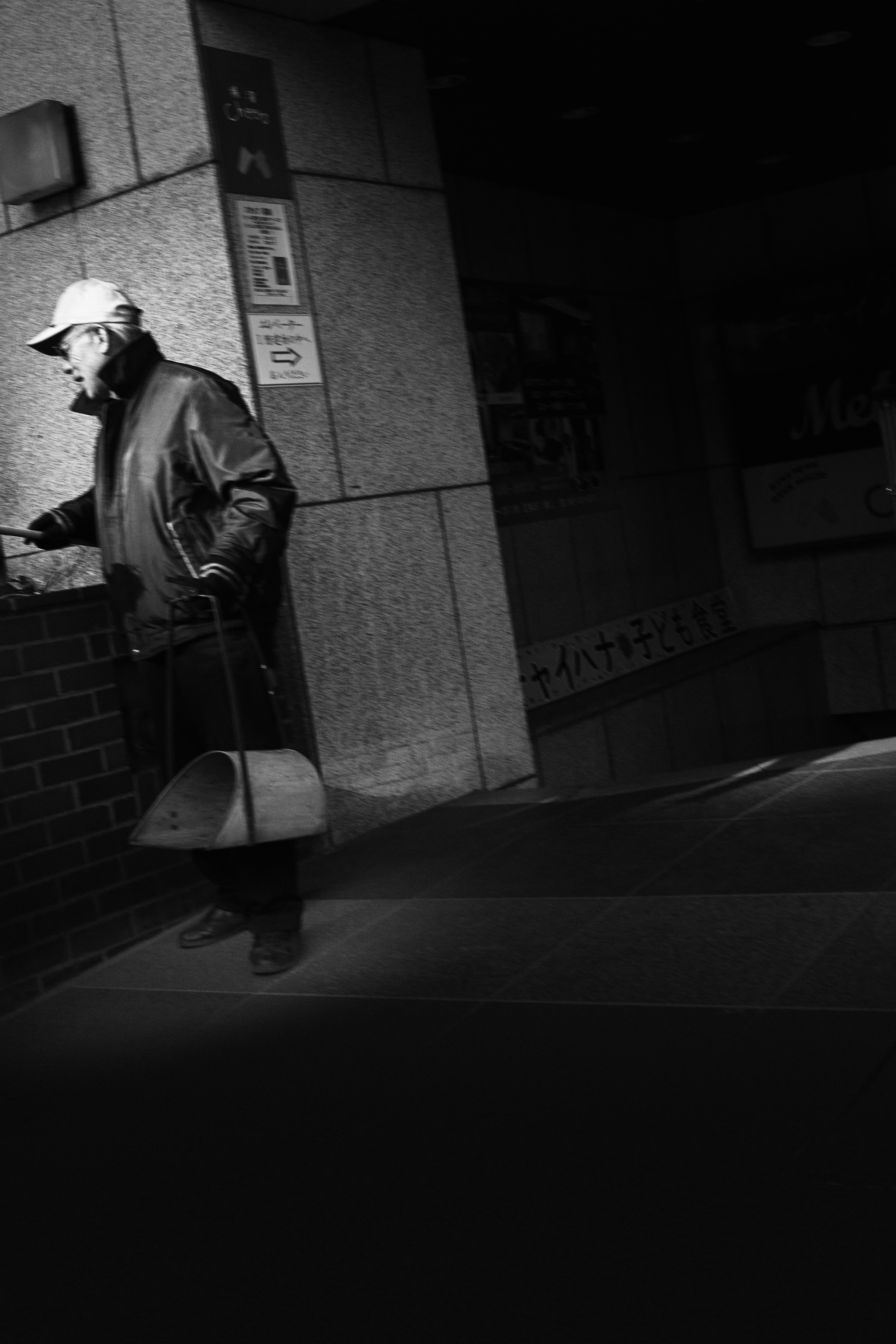 a person holding an umbrella in a nighttime alley with streetlight glow
