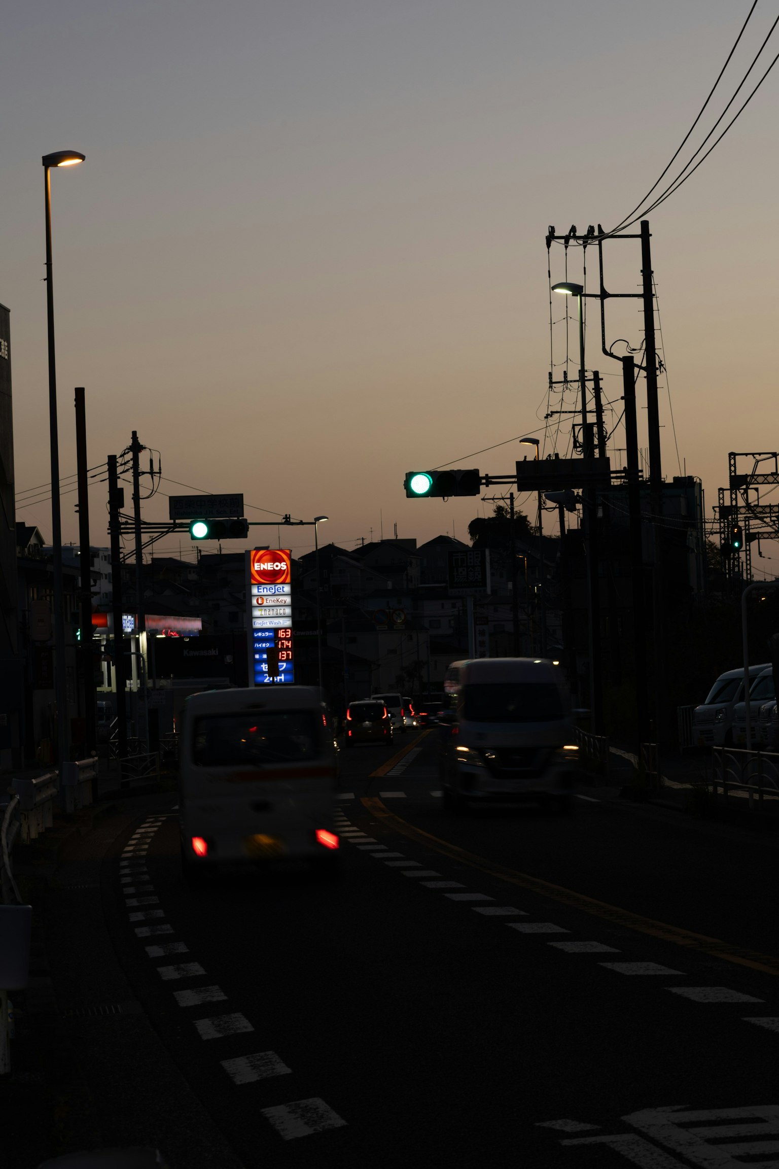 Paysage urbain au crépuscule avec des véhicules sur la route feux de circulation et lampadaires illuminés