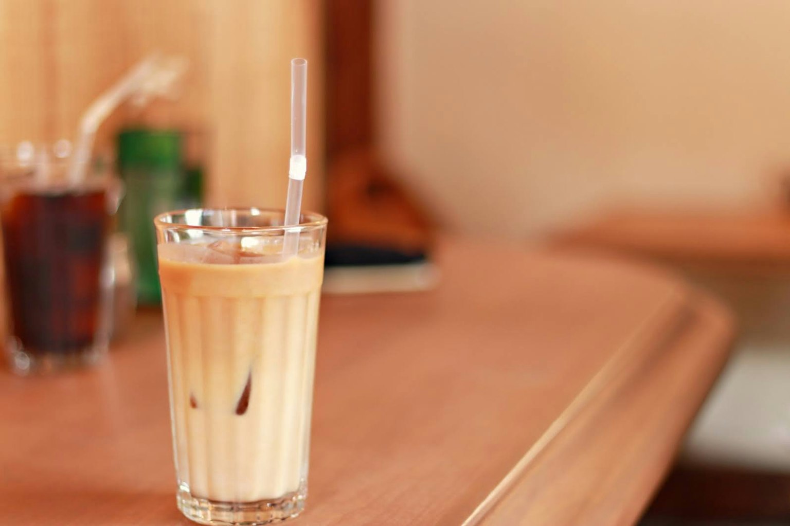 一杯裝有冰咖啡的透明玻璃杯放在木桌上