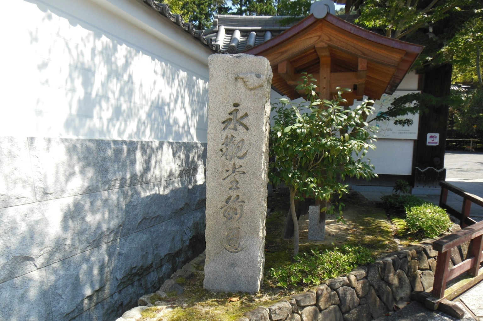 Monument en pierre avec inscriptions entouré de verdure