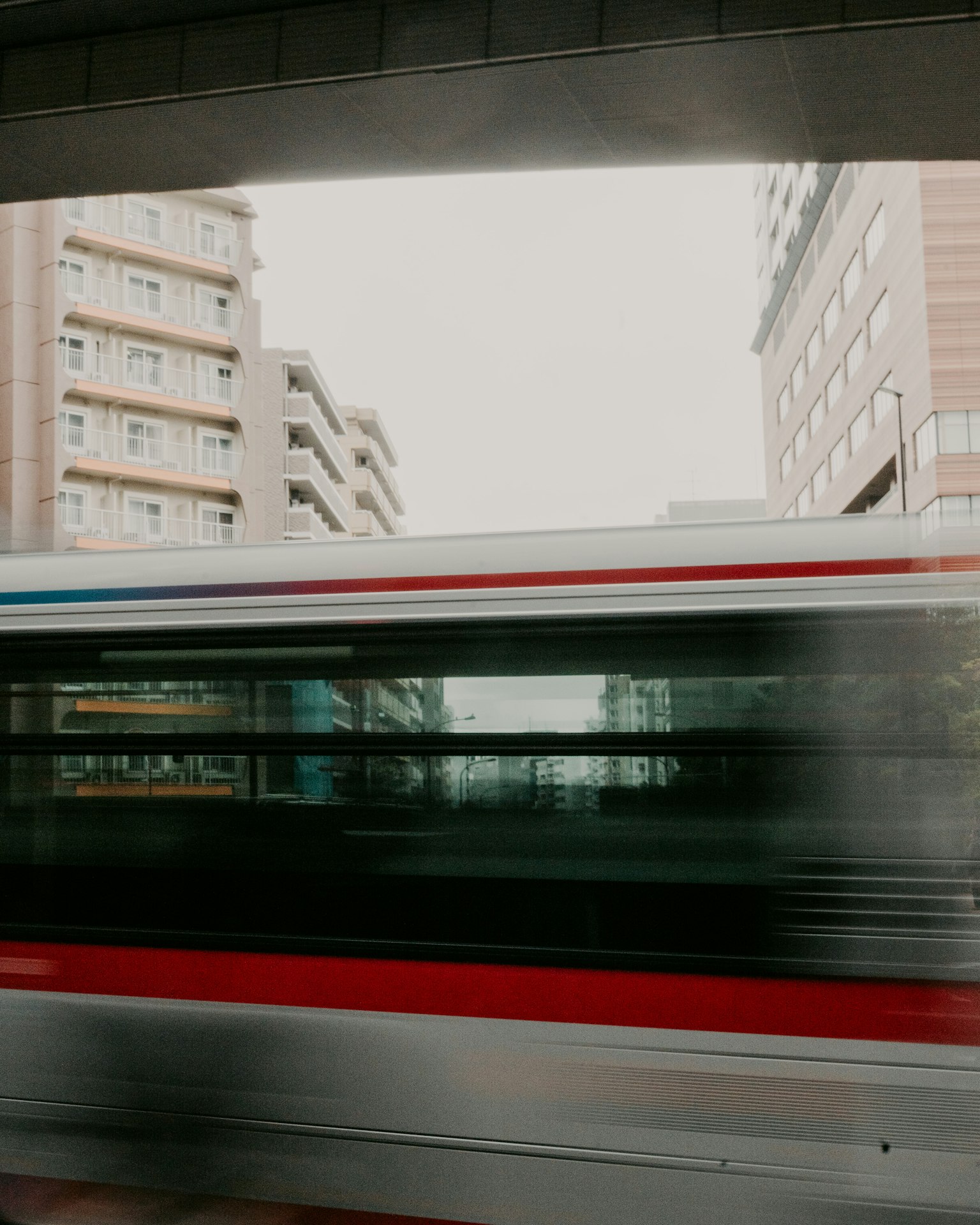 Train flou passant avec des bâtiments urbains en arrière-plan